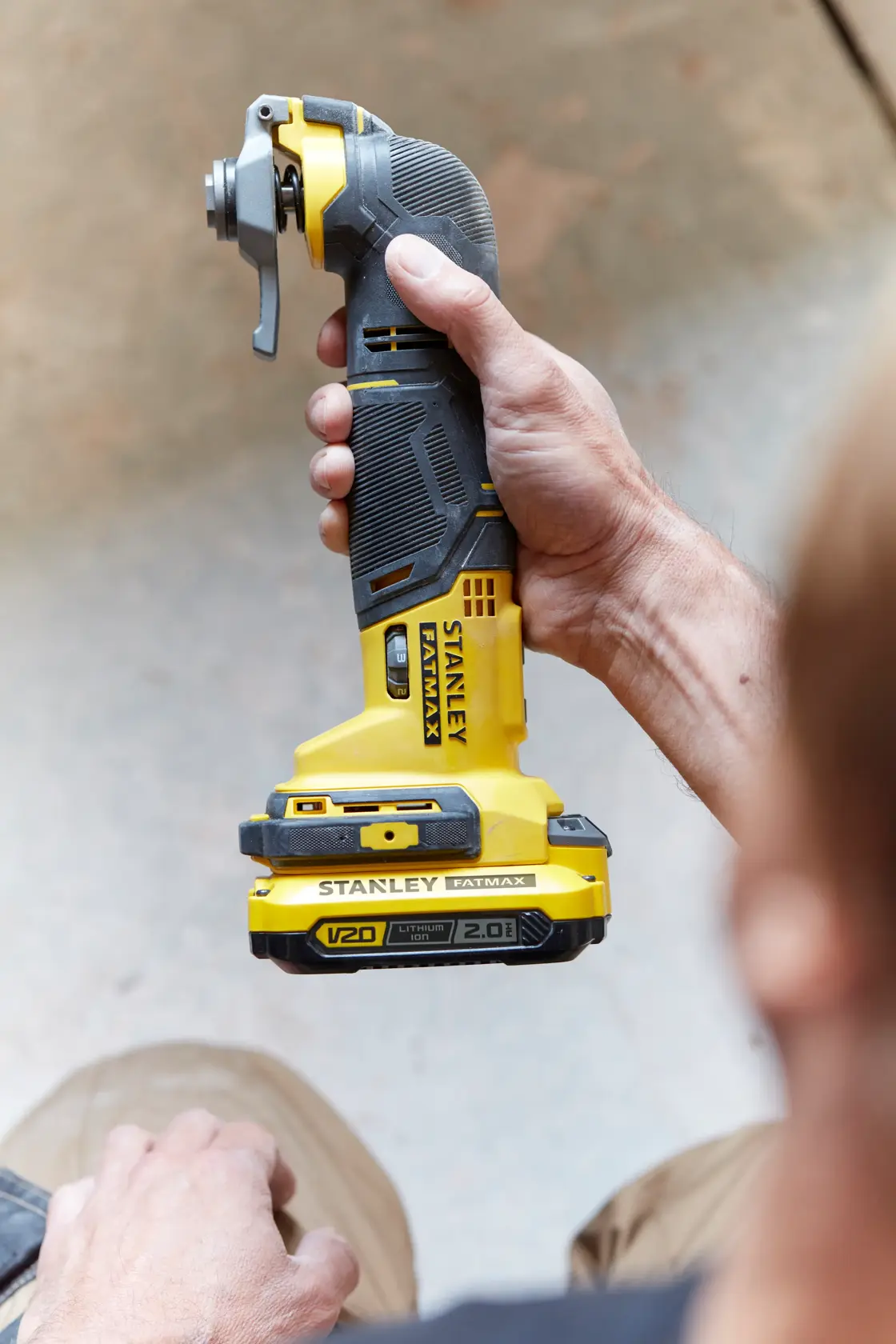 Foto dello STANLEY SFMCE500D2K utensile multifunzione cordless giallo e nero tenuto in mano.