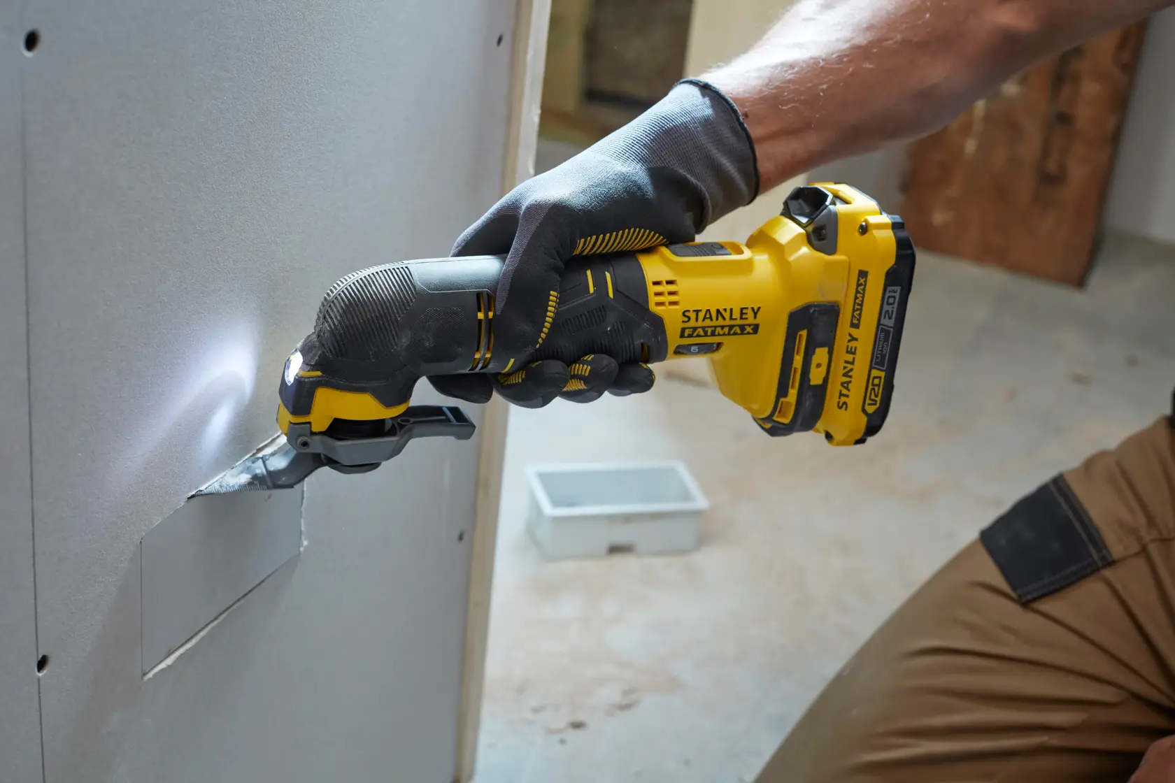 Foto del multiutensile oscillante STANLEY SFMCE500D2K che taglia cartongesso, vista laterale.