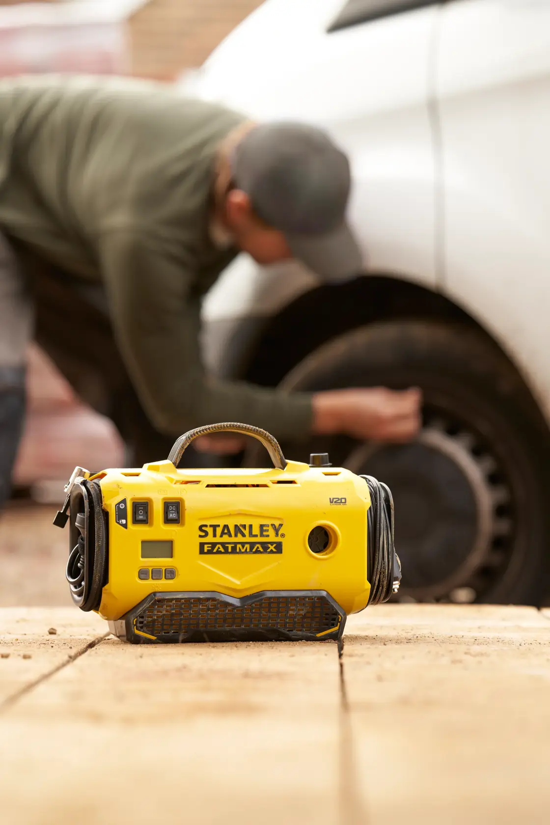 STANLEY SFMCE520B FATMAX gonfiatore portatile giallo all’aperto, usato da una persona vicino a una gomma d’auto.
