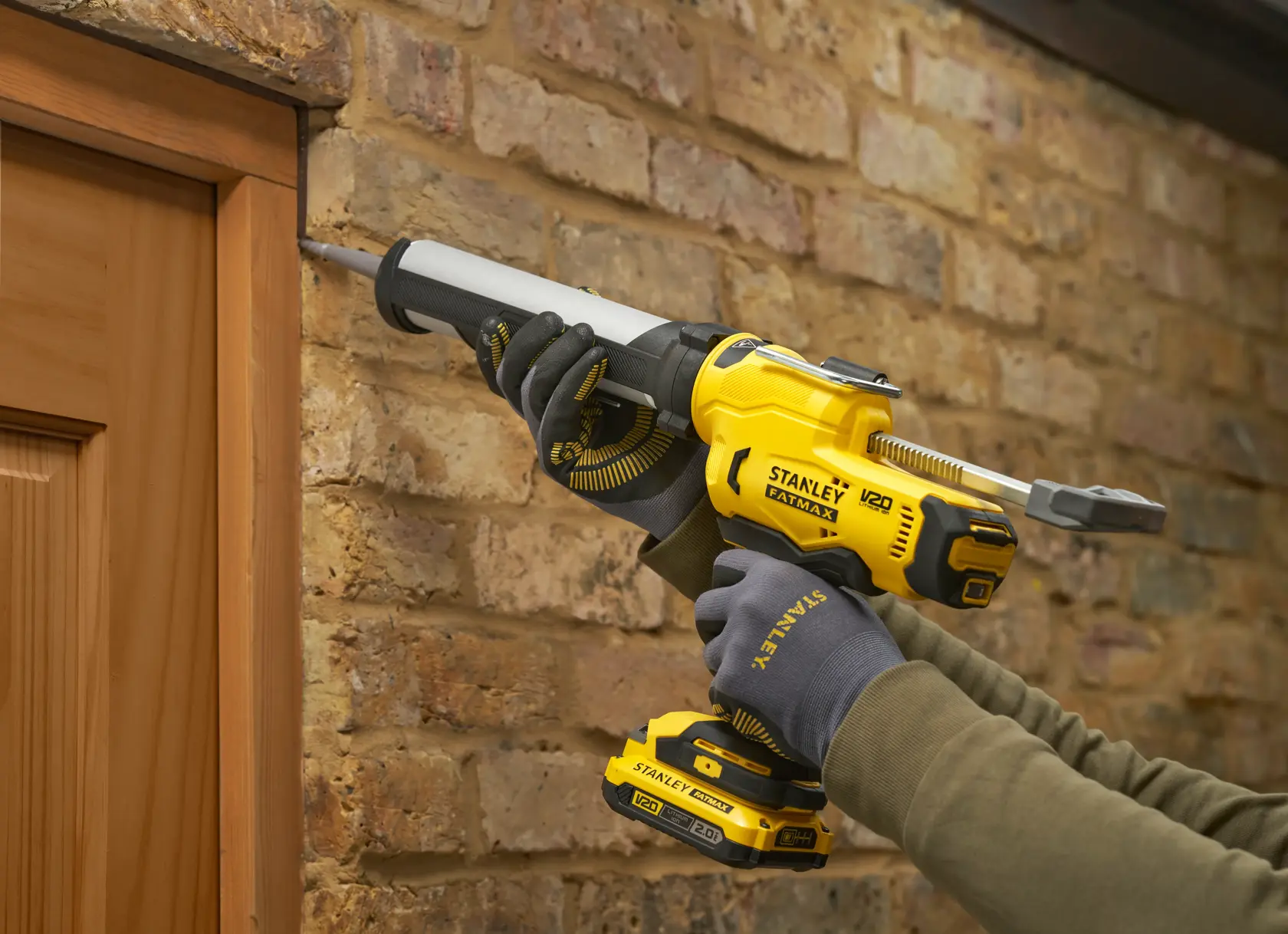 STANLEY SFMCE600B pistola per sigillare utilizzata intorno a un telaio in legno contro un muro in mattoni.
