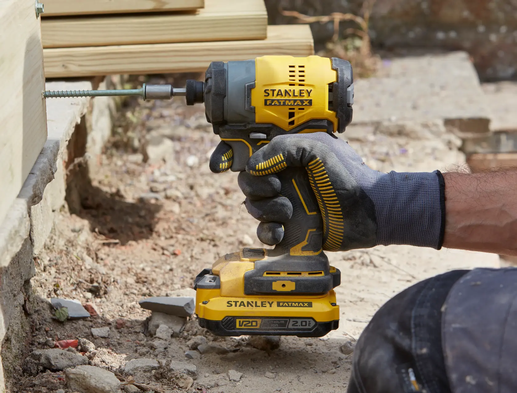 Stanley SFMCF810B avvitatore a impulsi tenuto da mano con guanto, avvita vite nel legno, ambiente esterno.