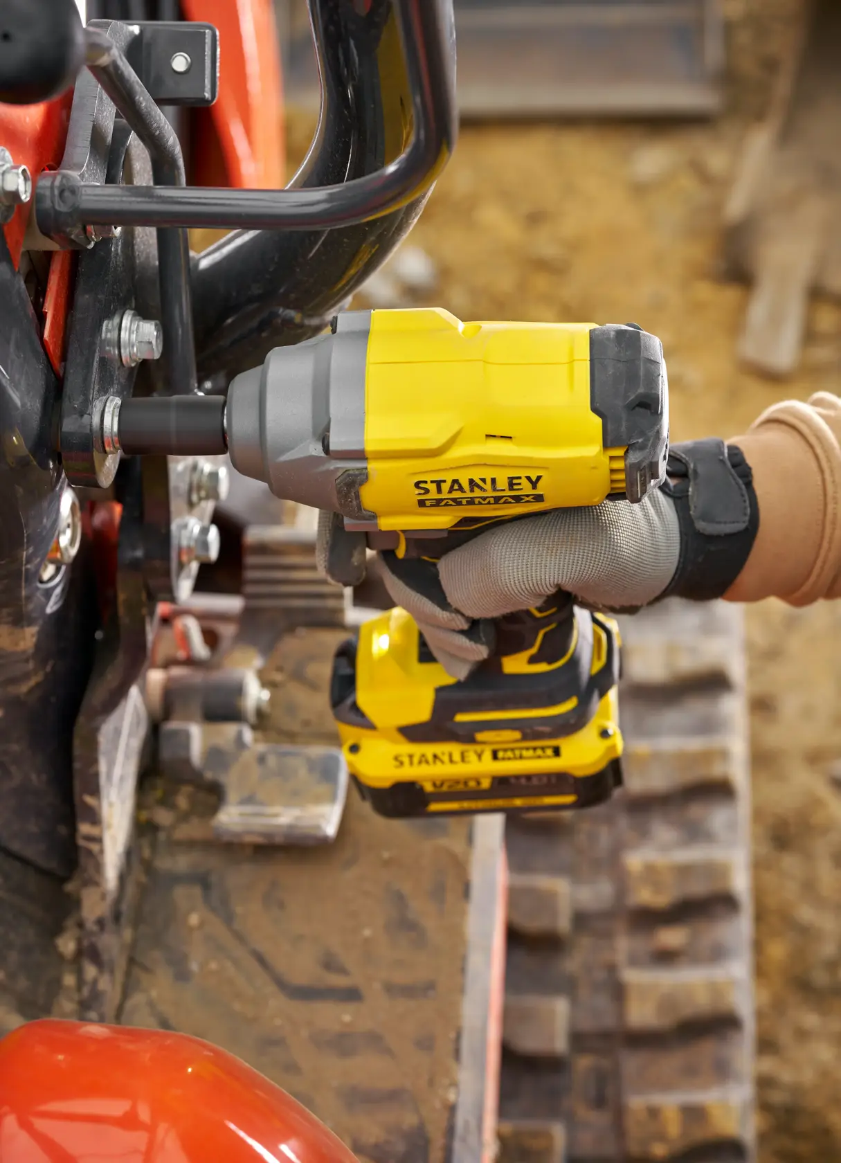 STANLEY SFMCF920B avvitatore a impulsi in uso, vista laterale, giallo e nero, stringe bullone su macchinario.