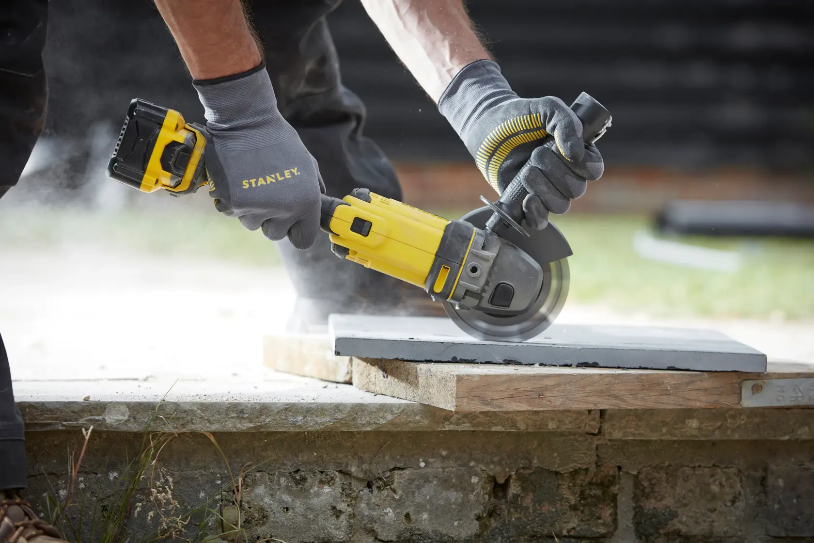 STANLEY SFMCG400M2K smerigliatrice angolare senza fili usata per tagliare cemento, primo piano all’aperto.