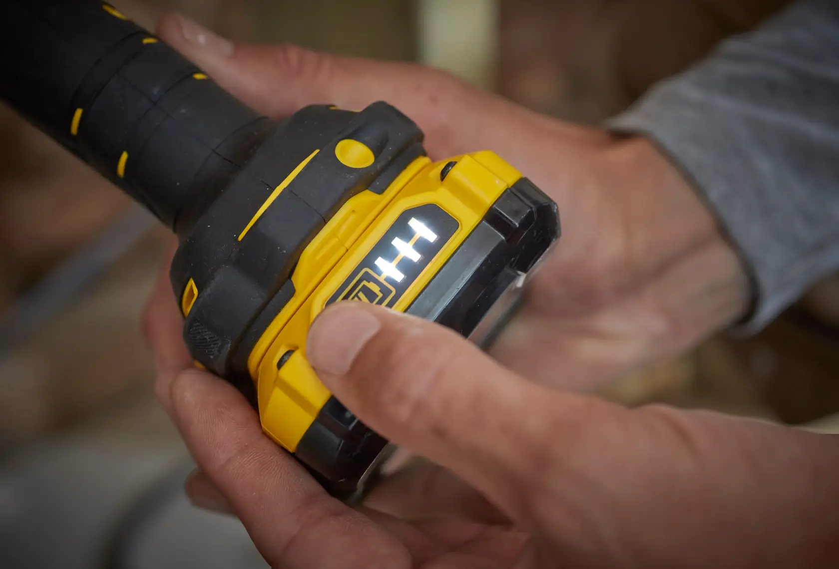 STANLEY SFMCL020B batteria gialla e nera con indicatore LED tenuta in mano, fotografia ravvicinata.