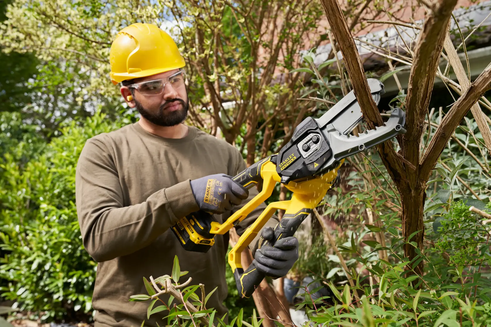 STANLEY SFMCPS515B potatrice a batteria in uso, taglia rami di alberi all’aperto.