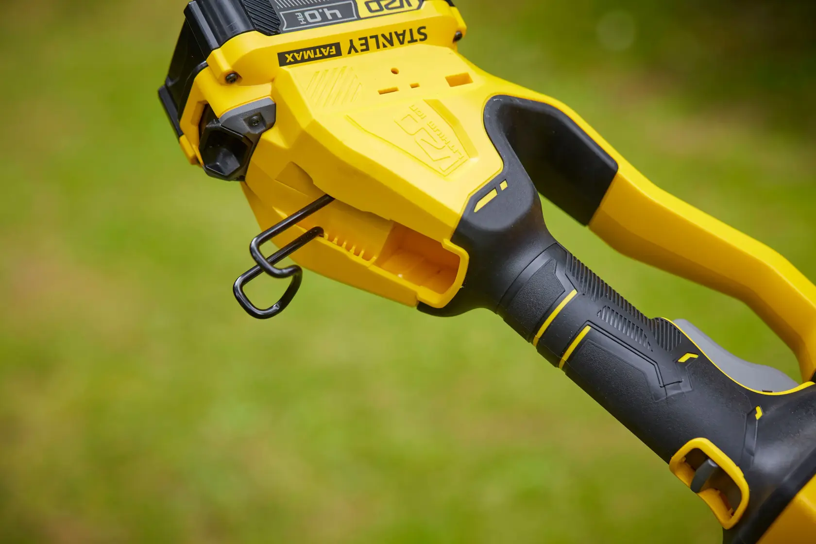 Primo piano del manico del tagliabordi STANLEY SFMCPS620B con impugnatura ergonomica gialla e nera e gancio.