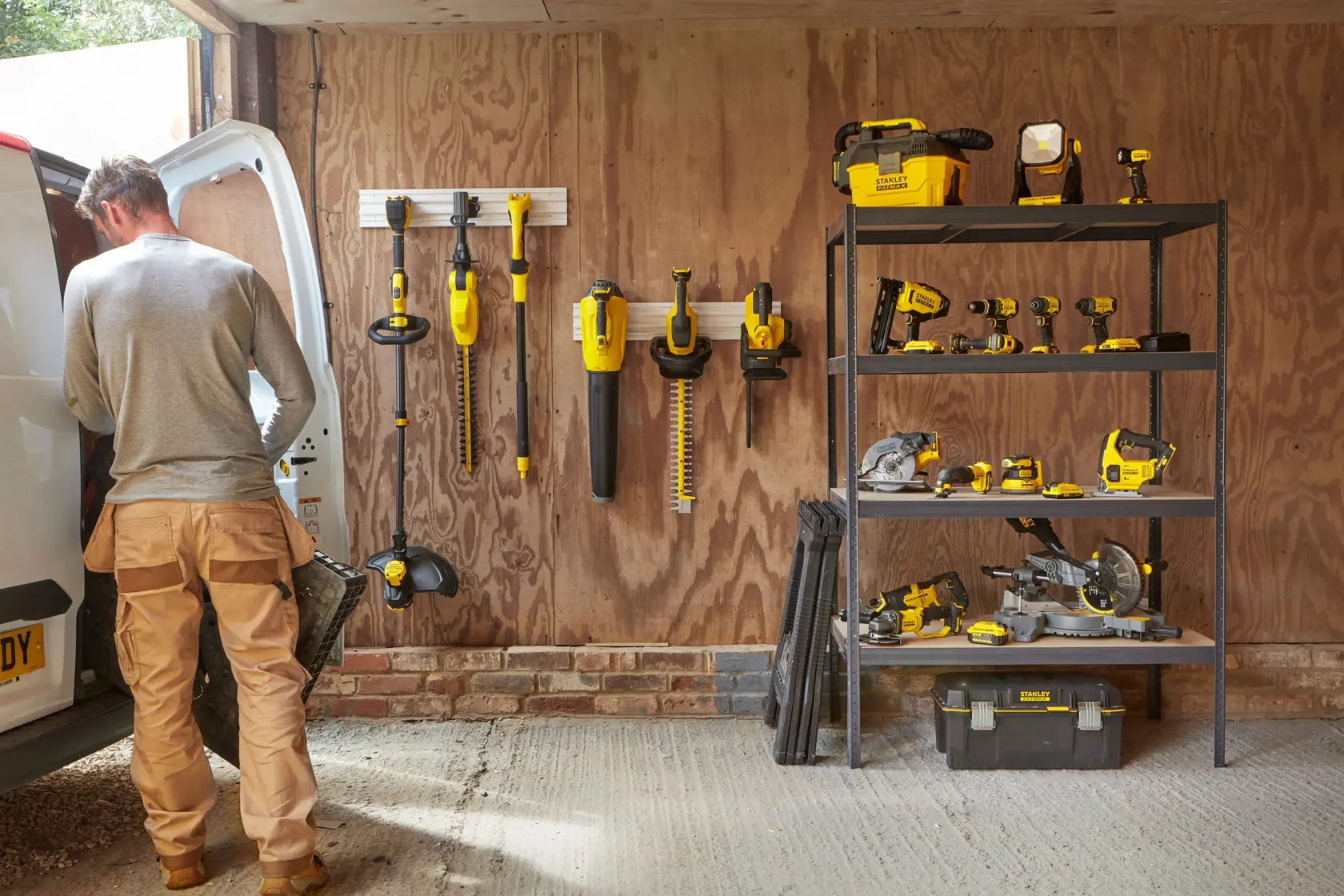 Utensili e accessori STANLEY SFMCPS620B organizzati in garage, scaffalature e sistema a parete visibili.