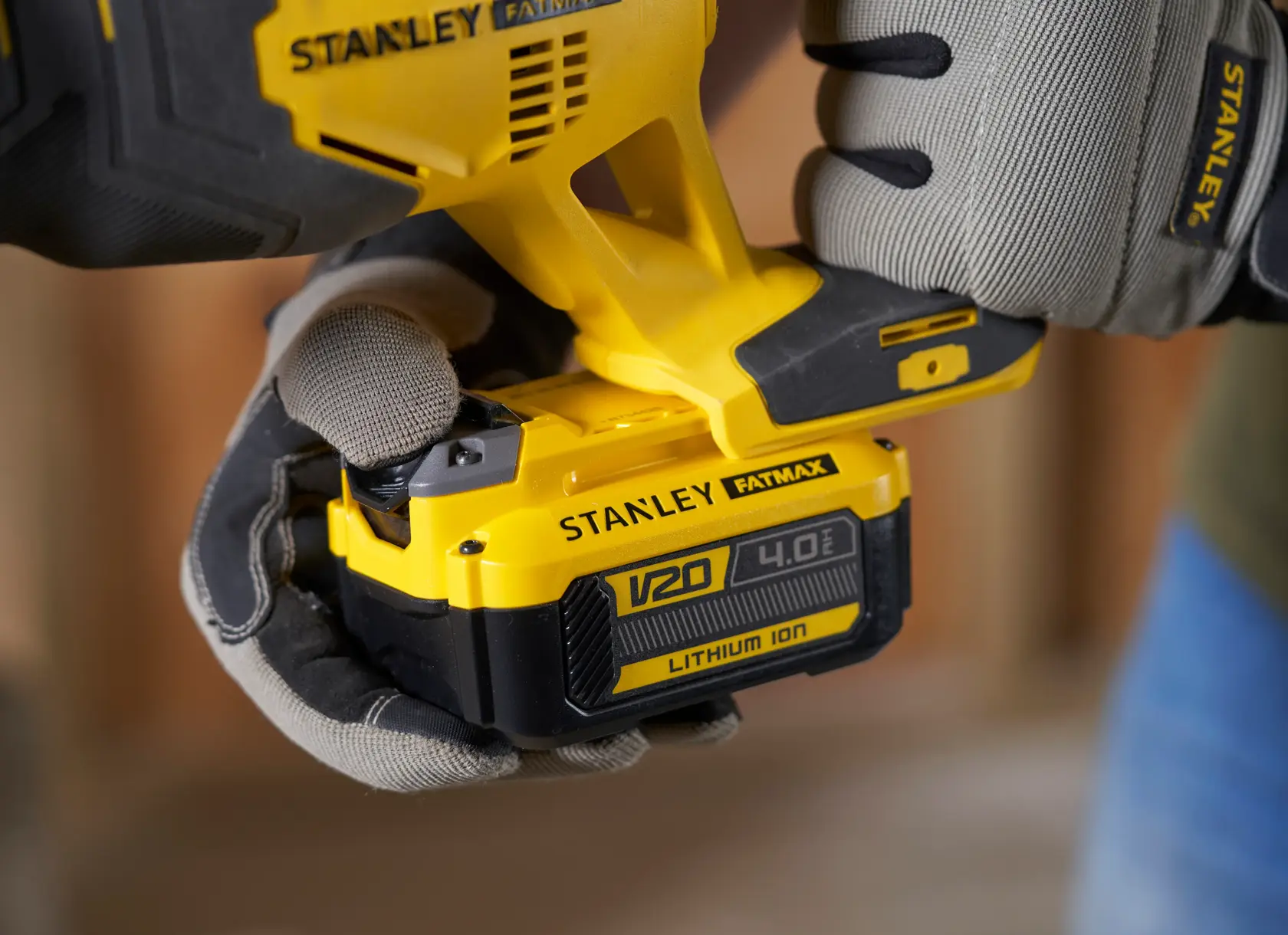 Fotografia di STANLEY SFMCS300B utensile con batteria V20 4.0Ah al litio tenuto da mani con guanti.