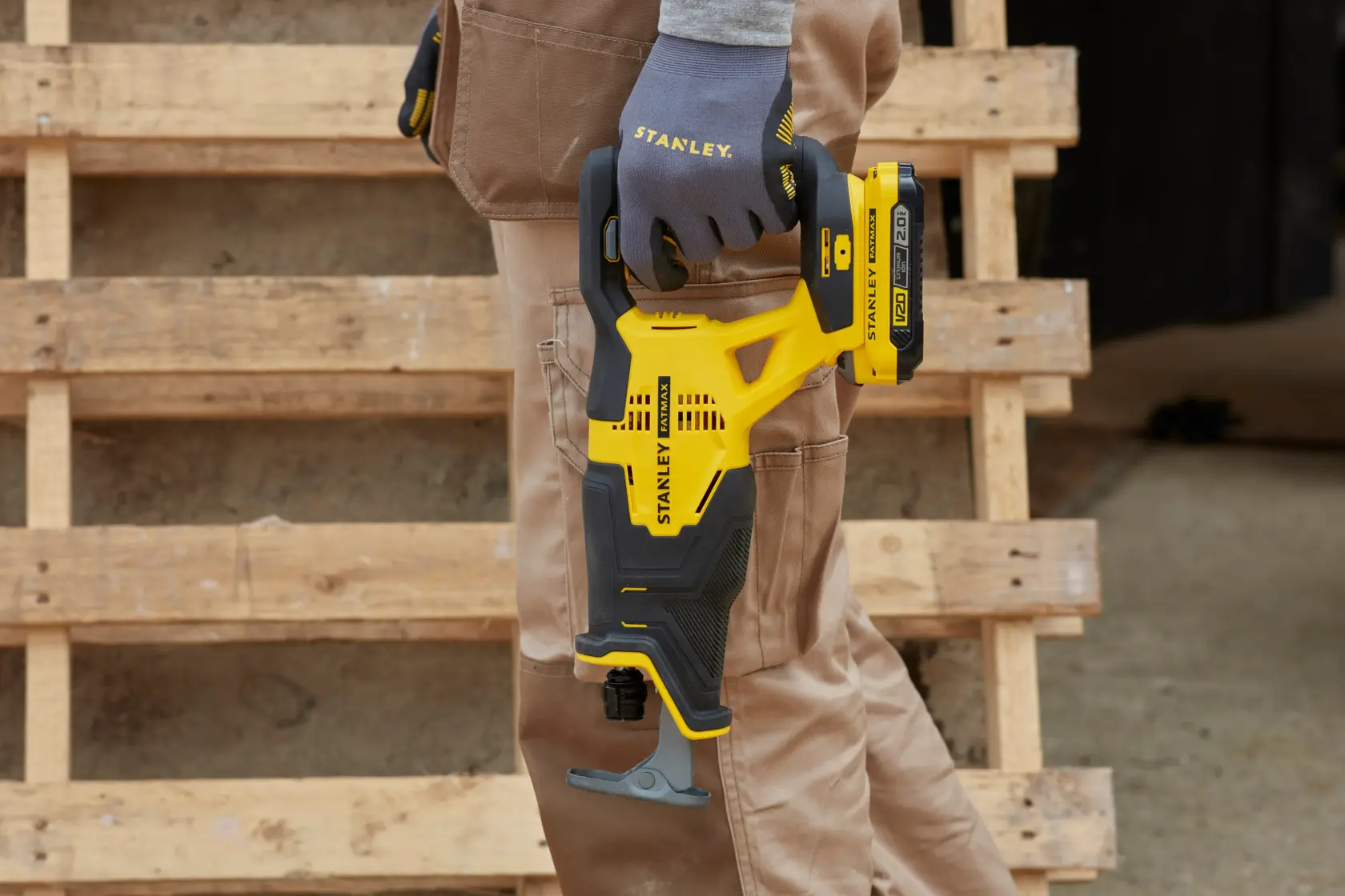 STANLEY SFMCS300B sega reciproca tenuta da una mano con guanto, design giallo e nero, ambientazione da cantiere.