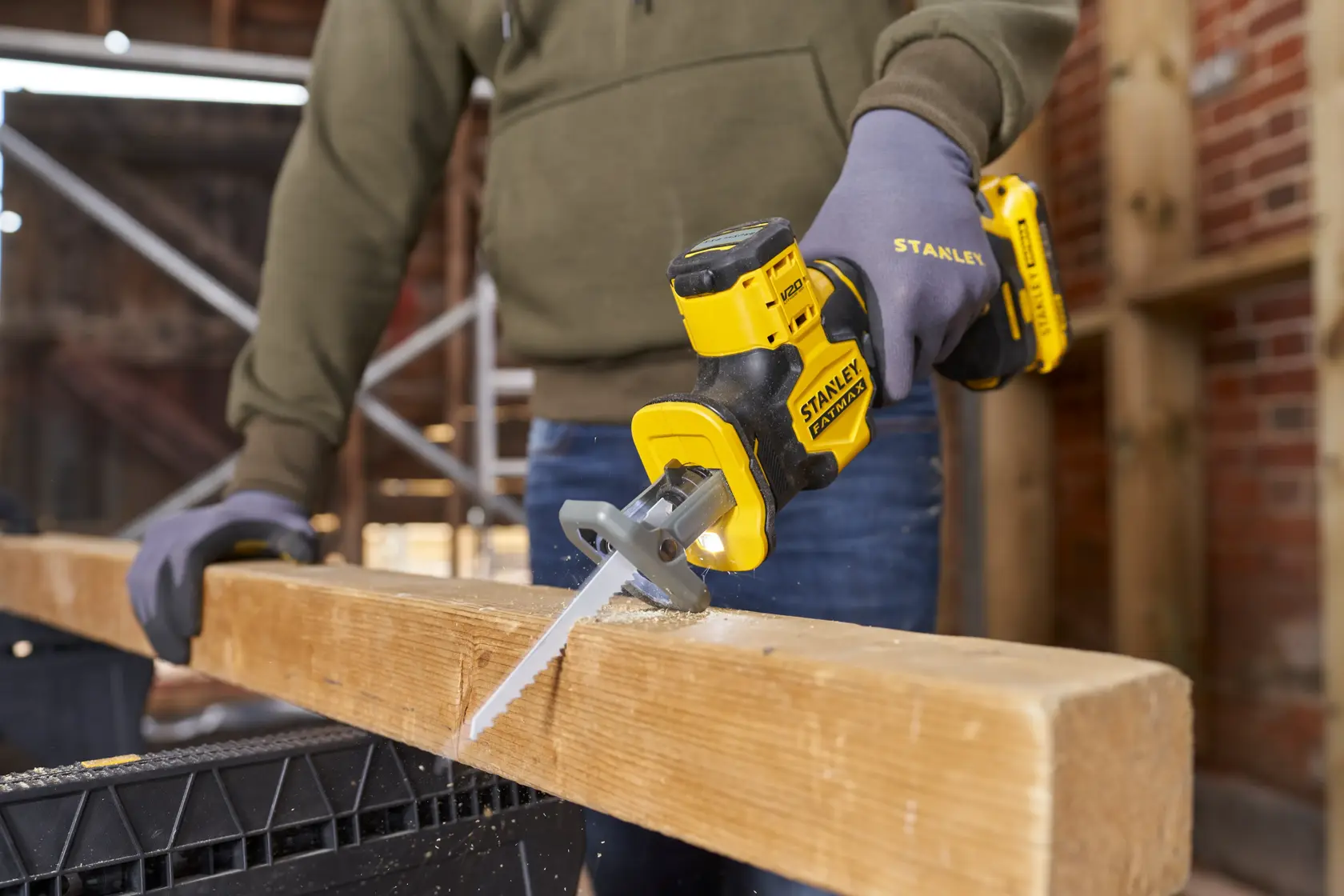 Foto del seghetto alternativo a batteria STANLEY SFMCS305B che taglia una trave in legno in cantiere.