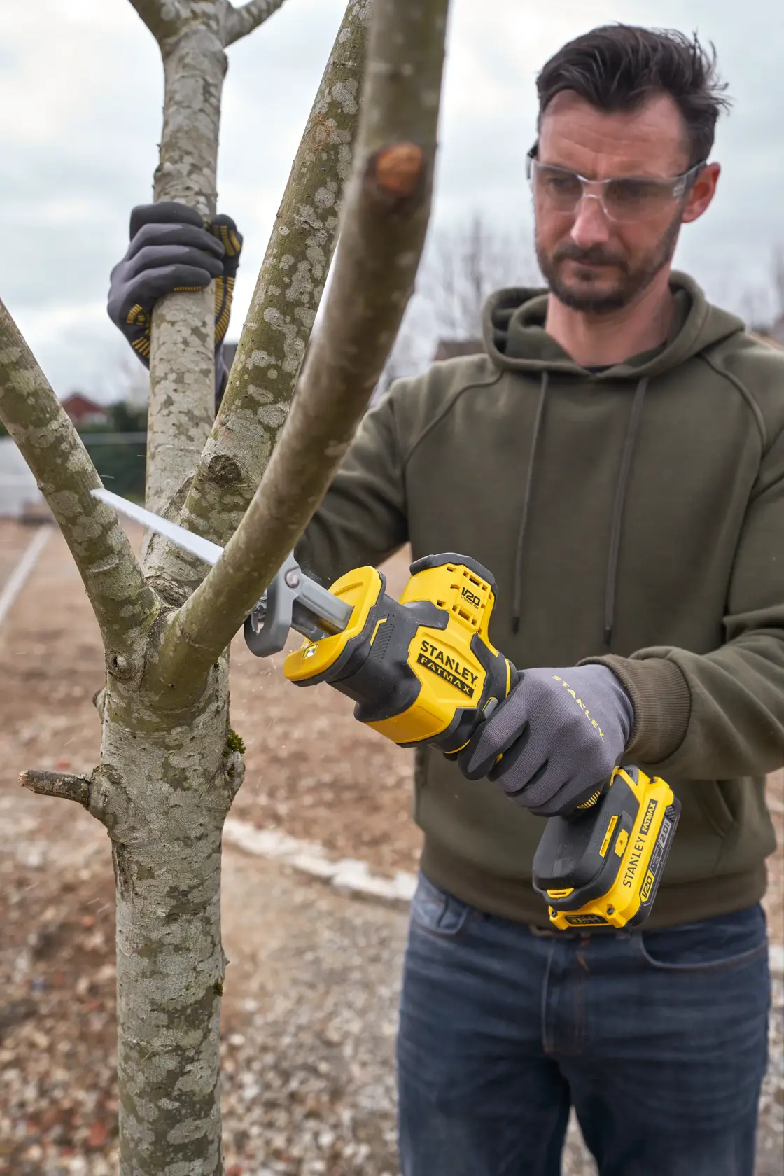 Foto di STANLEY SFMCS305B seghetto alternativo cordless utilizzato per tagliare un ramo all'aperto.