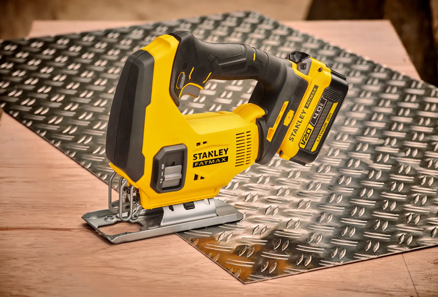 Foto del seghetto alternativo STANLEY SFMCS600B su una lastra metallica, utensile a batteria giallo e nero, vista laterale.