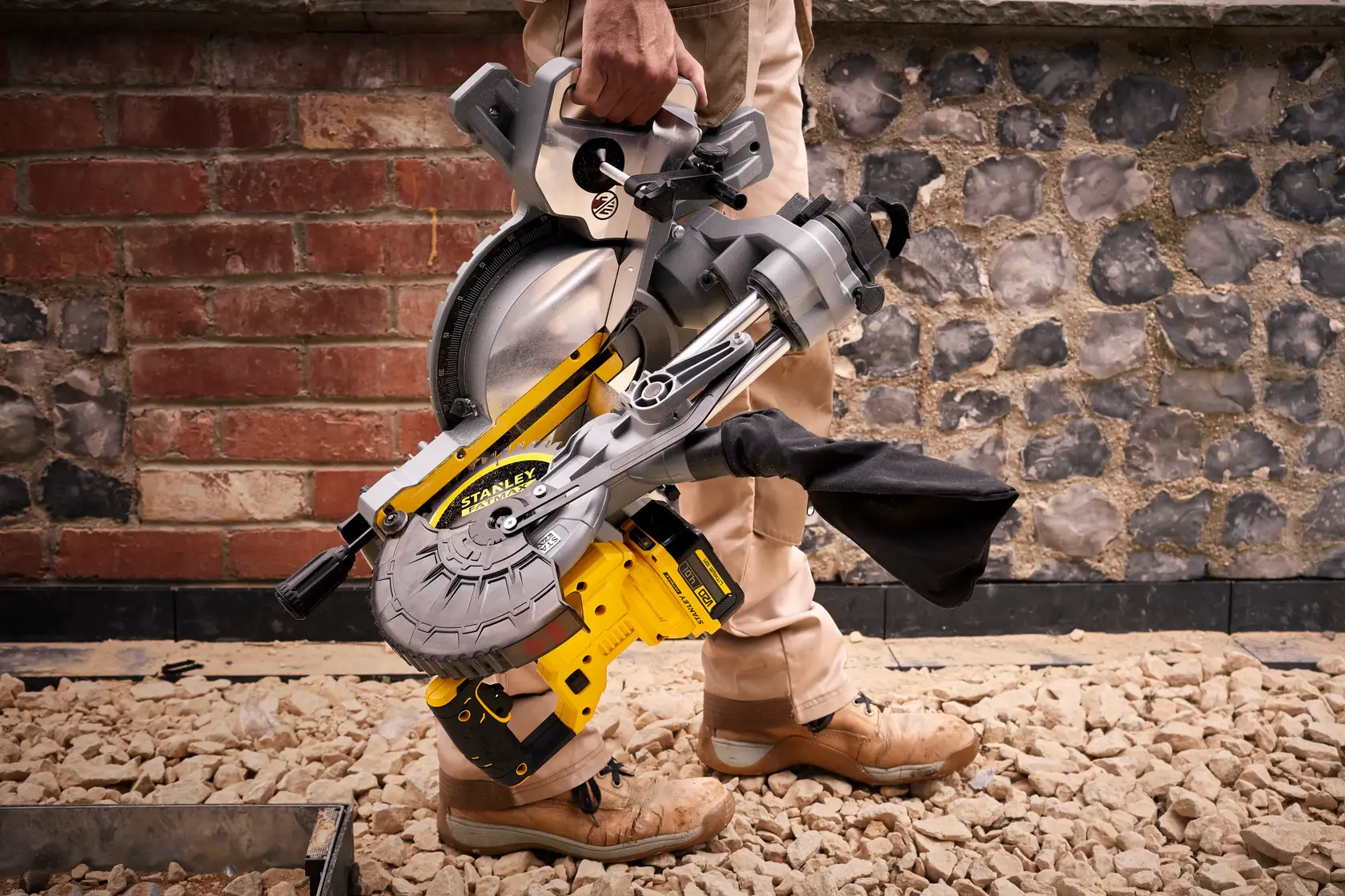 STANLEY SFMCS701M1 troncatrice gialla e argento, trasportata a mano su un cantiere.