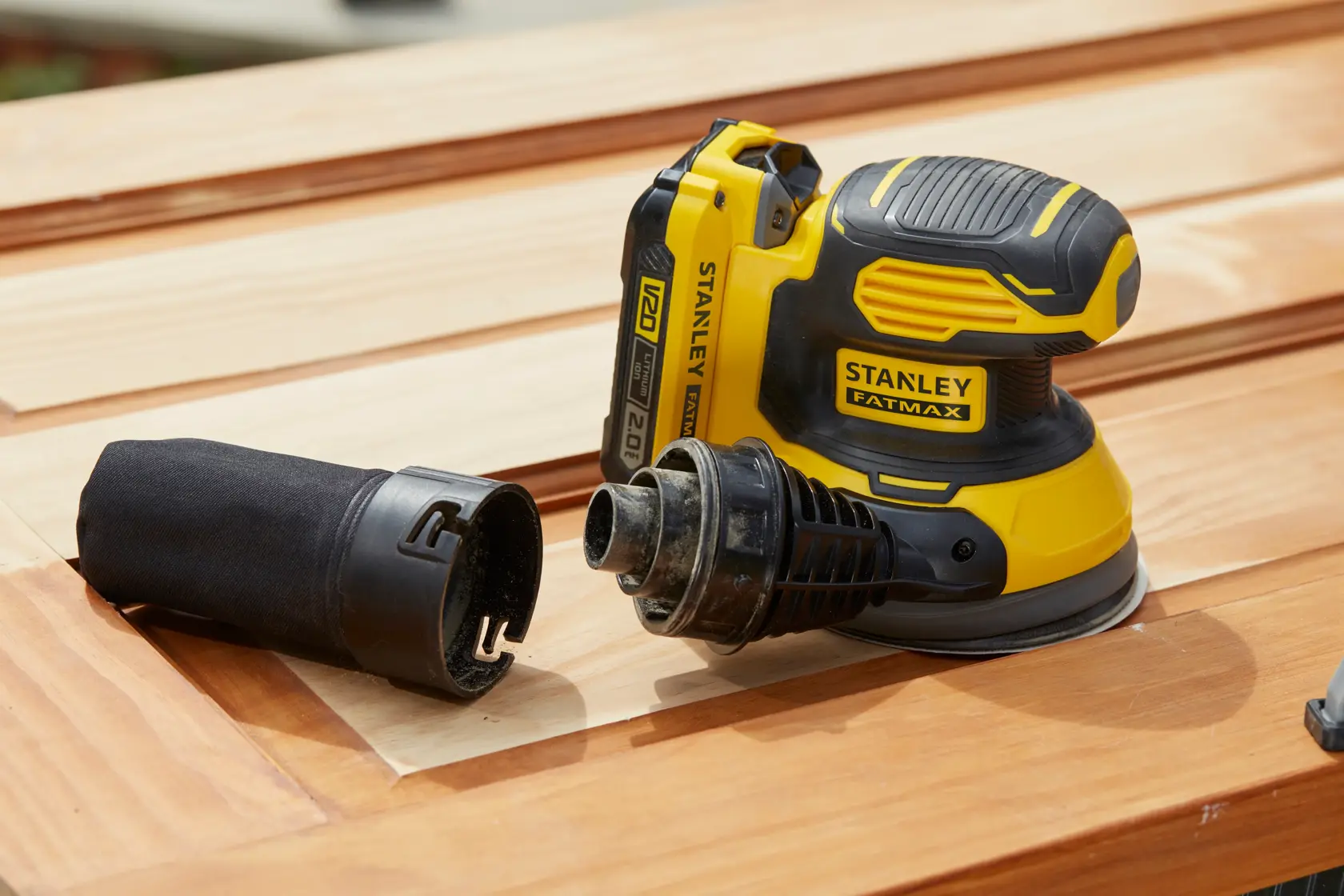 Stanley SFMCW220B levigatrice senza fili con porta polvere, giallo-nera, su superficie di legno, fotografia prodotto.