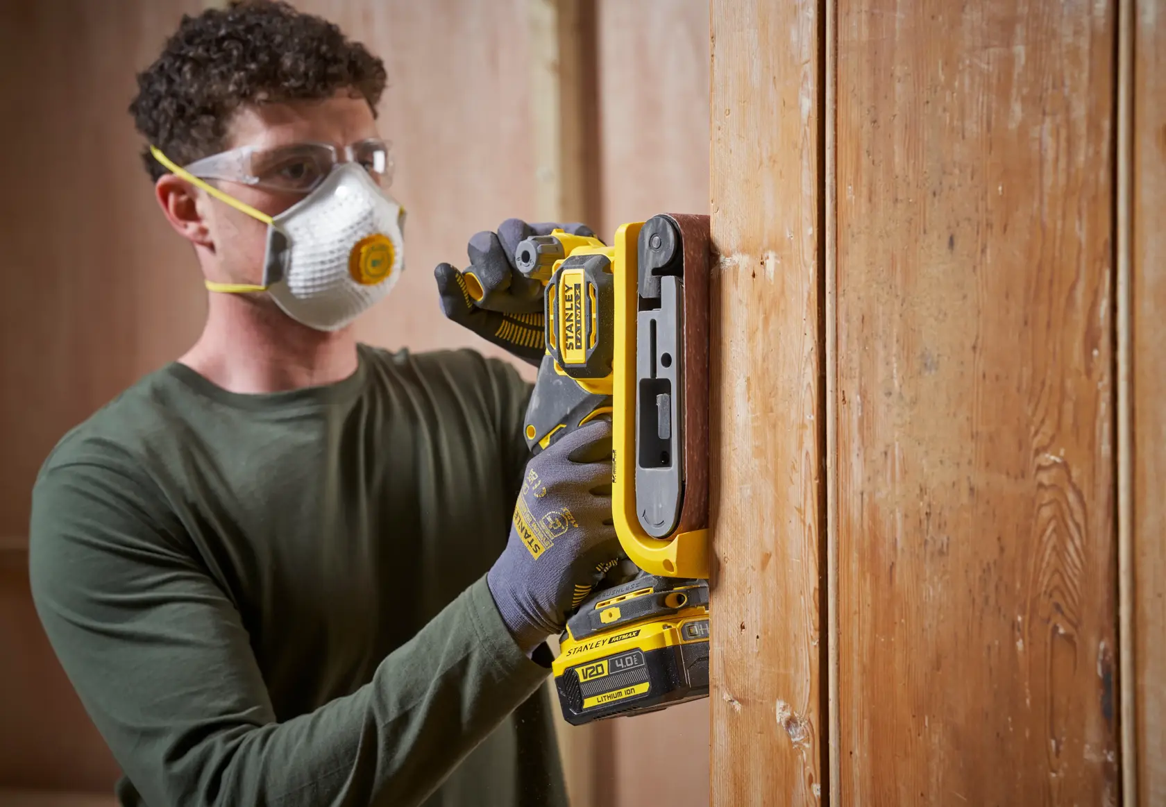 STANLEY SFMCW223B-XJ levigatrice senza fili in uso su superficie verticale di legno, fotografia ravvicinata.