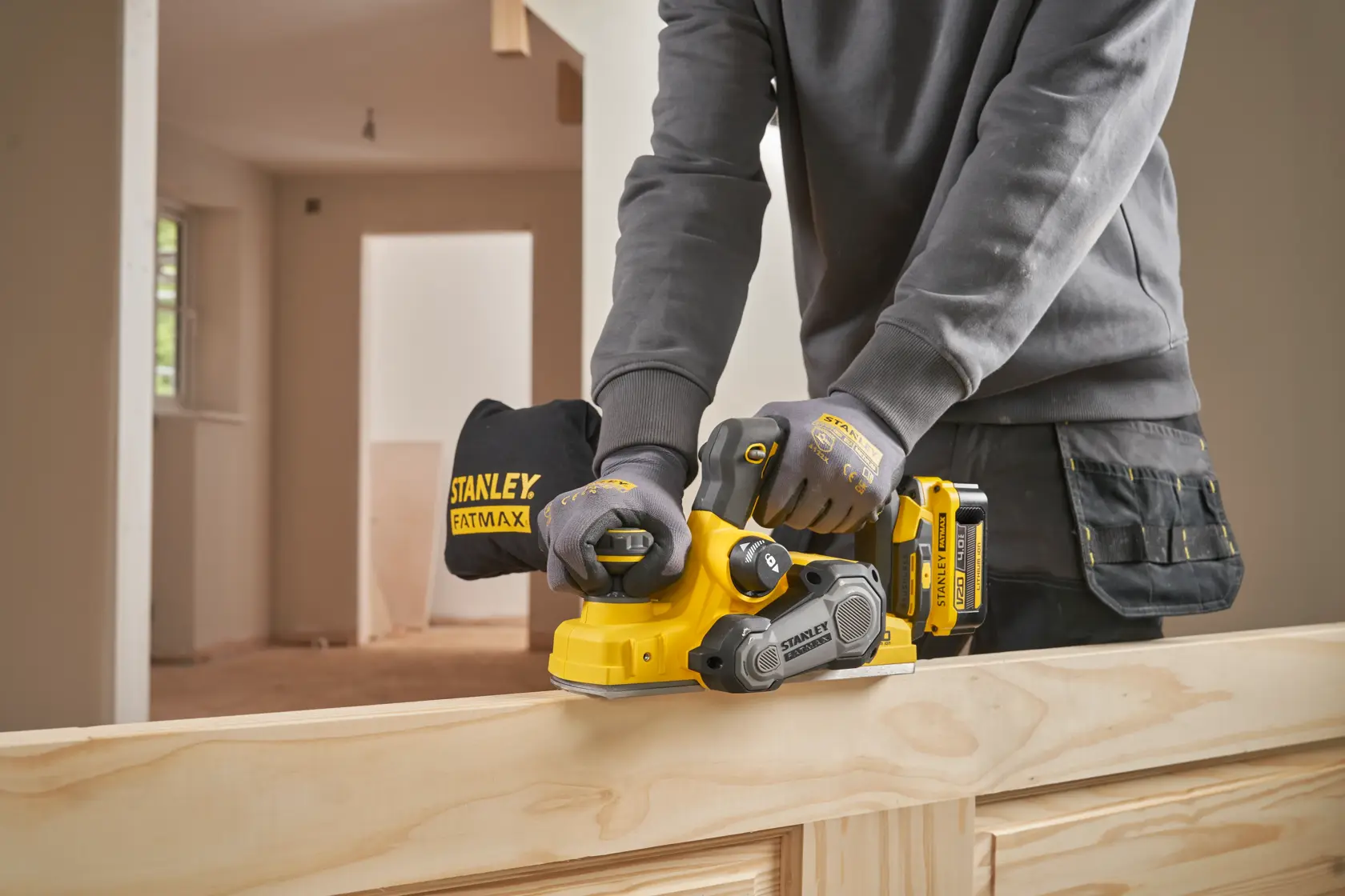 Stanley SFMCW300B piallatrice senza fili su legno, vista laterale, operaio con guanti.