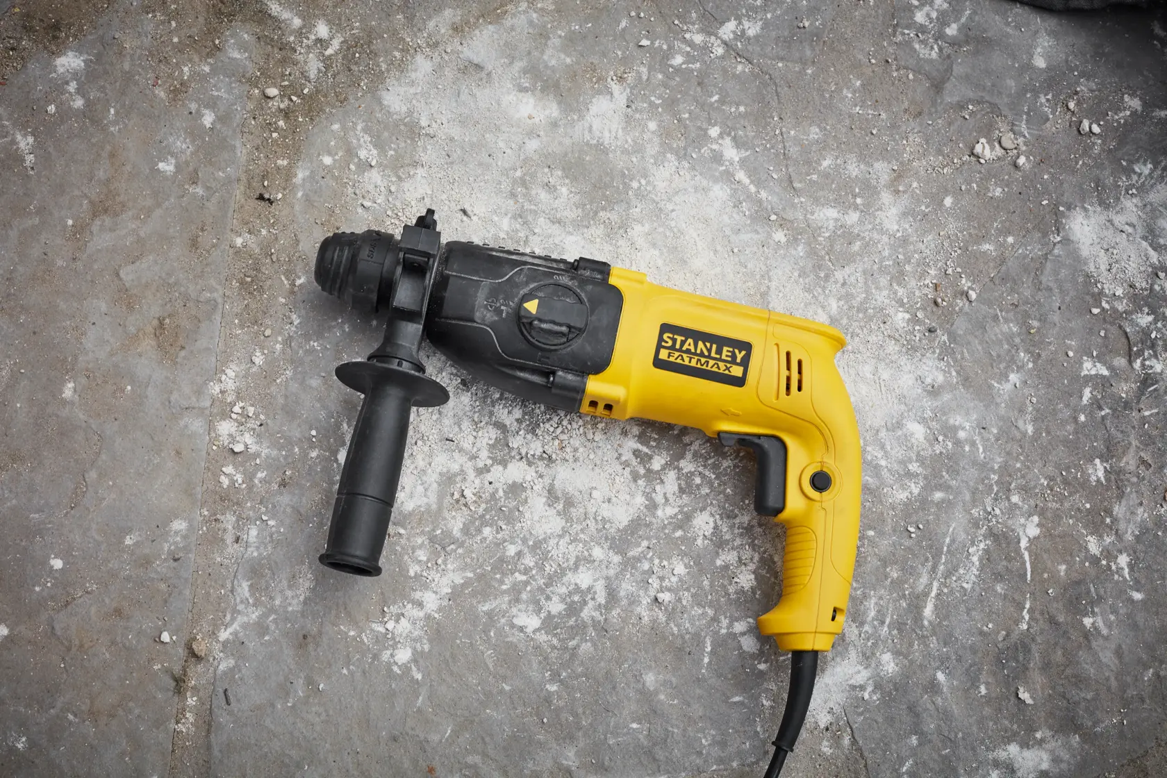 STANLEY SFMEH200K trapano martello giallo e nero con cavo e impugnatura laterale su cemento.