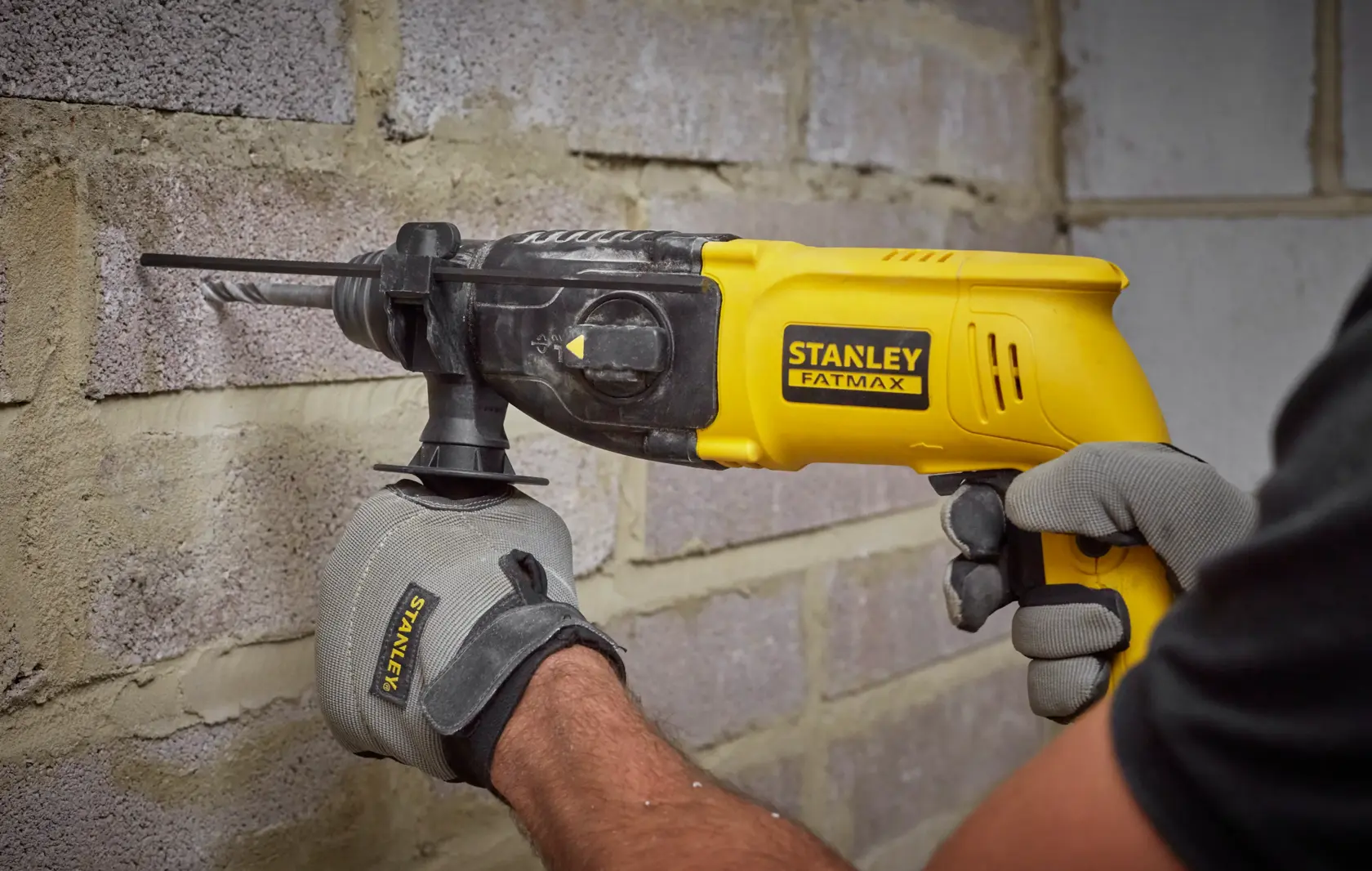 STANLEY SFMEH200K martello rotante in uso su muro di mattoni, giallo e nero, foto ravvicinata.