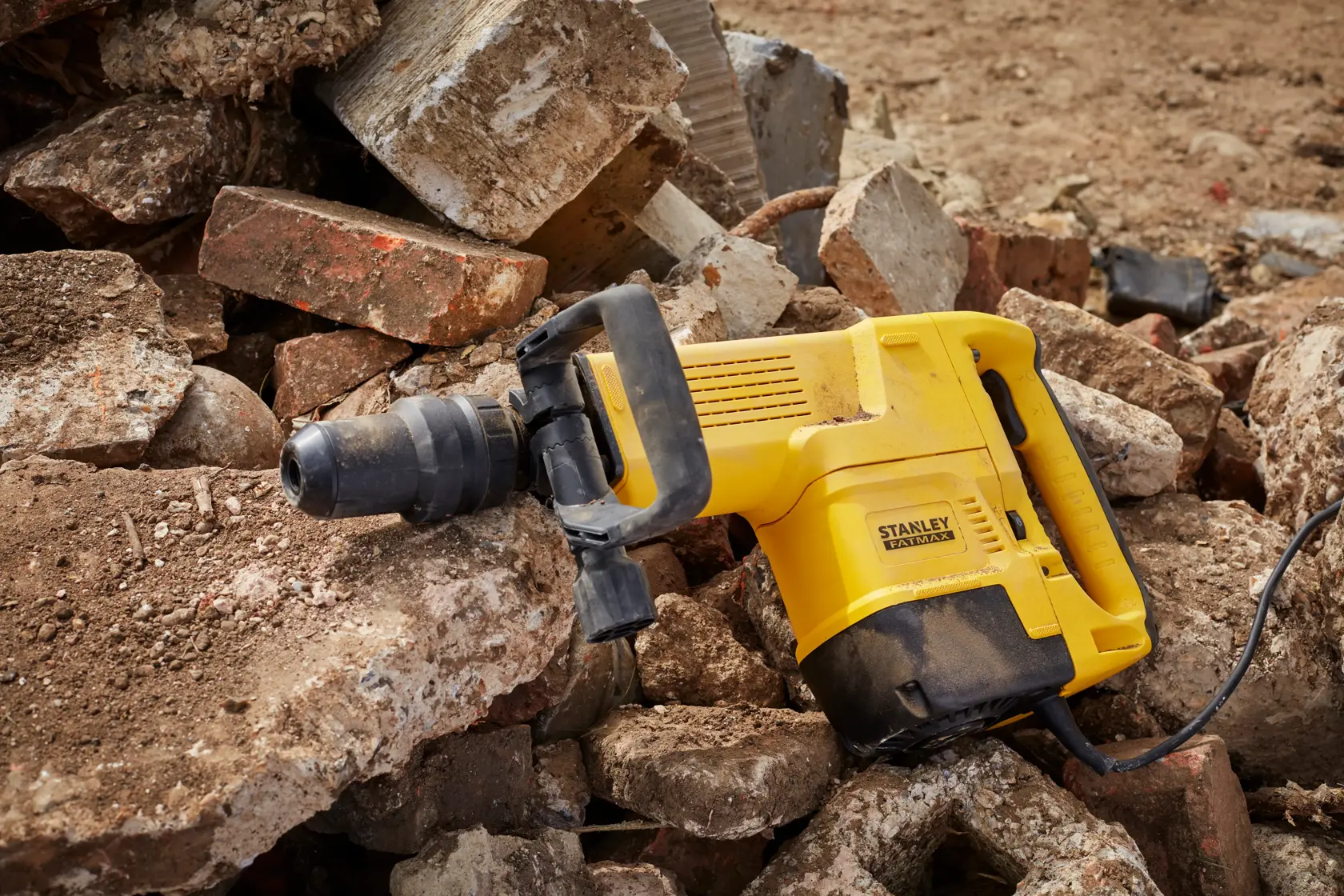 STANLEY SFMEH230K-QS martello demolitore su macerie, corpo giallo con manico nero, vista laterale.