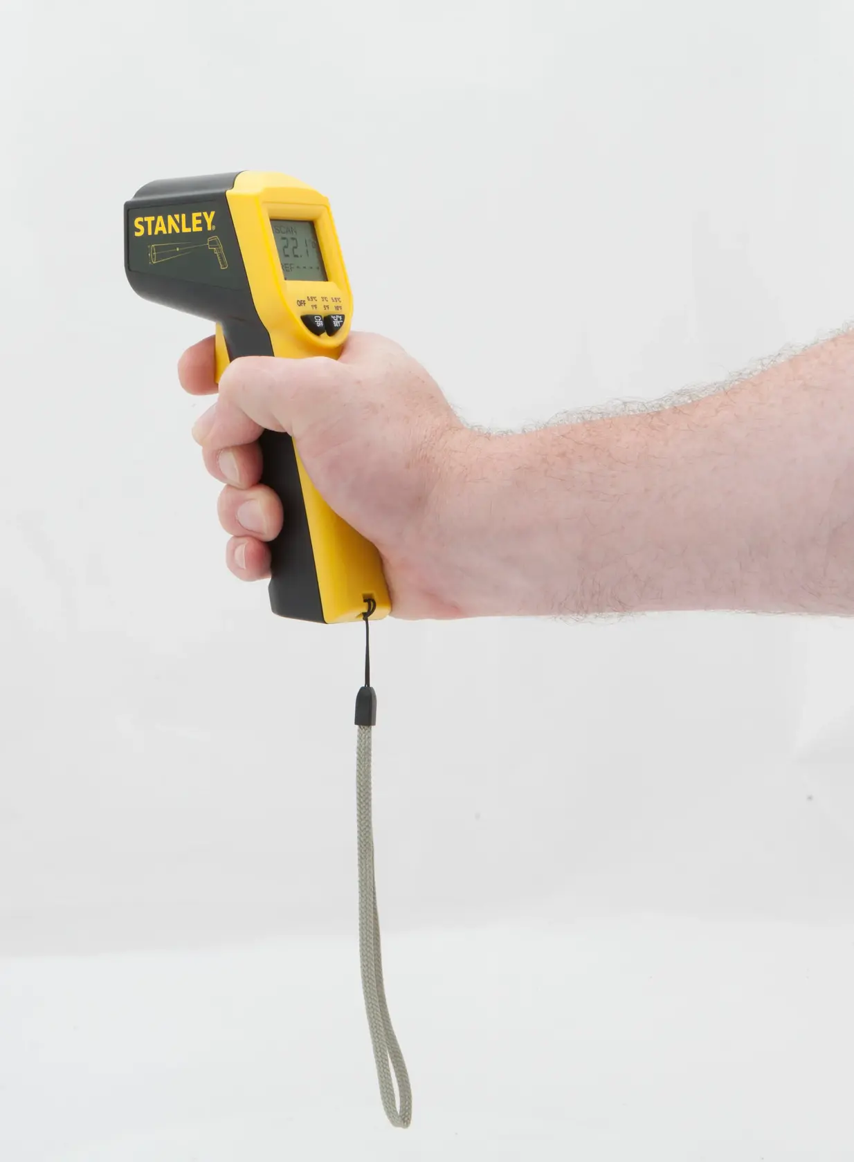 Termometro a infrarossi STANLEY STHT0-77365 con display, giallo e nero, mostrato in mano, vista laterale.