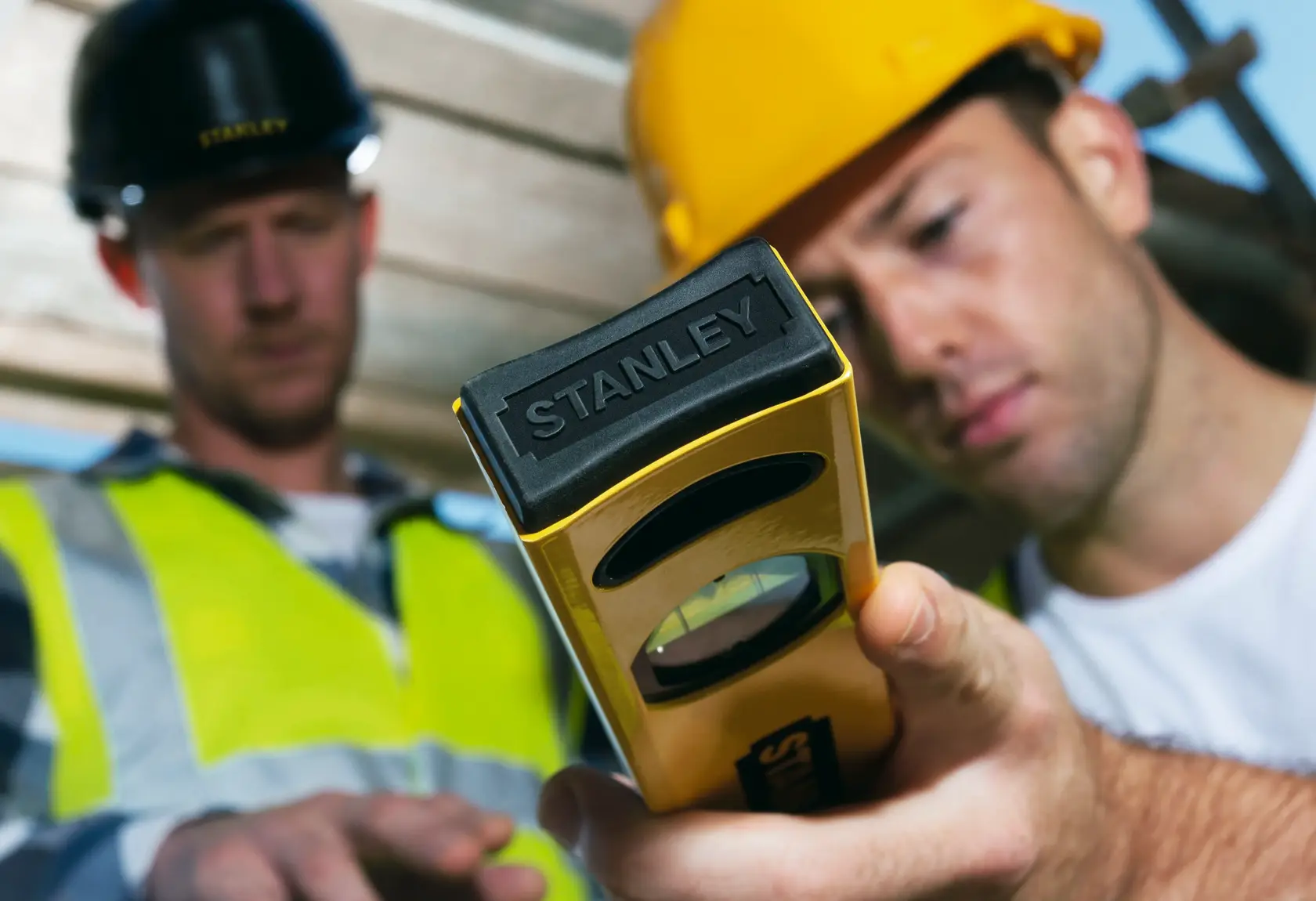 Foto dello strumento di livellamento STANLEY STHT1-43102 in uso in cantiere, primo piano strumento giallo e nero.