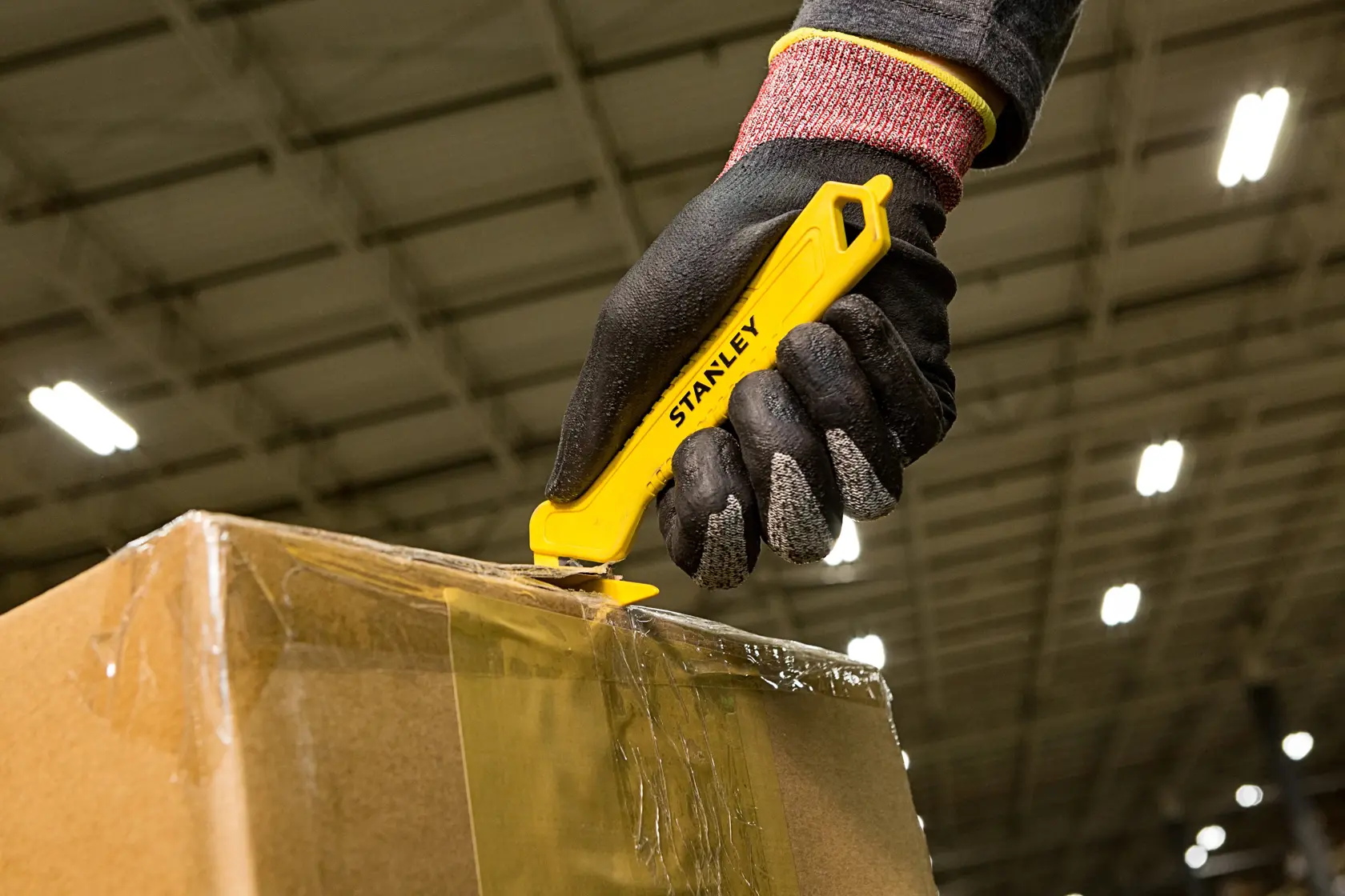 Stanley STHT10355-1 coltello da taglio di sicurezza giallo usato per tagliare il nastro di una scatola, fotografia ravvicinata.