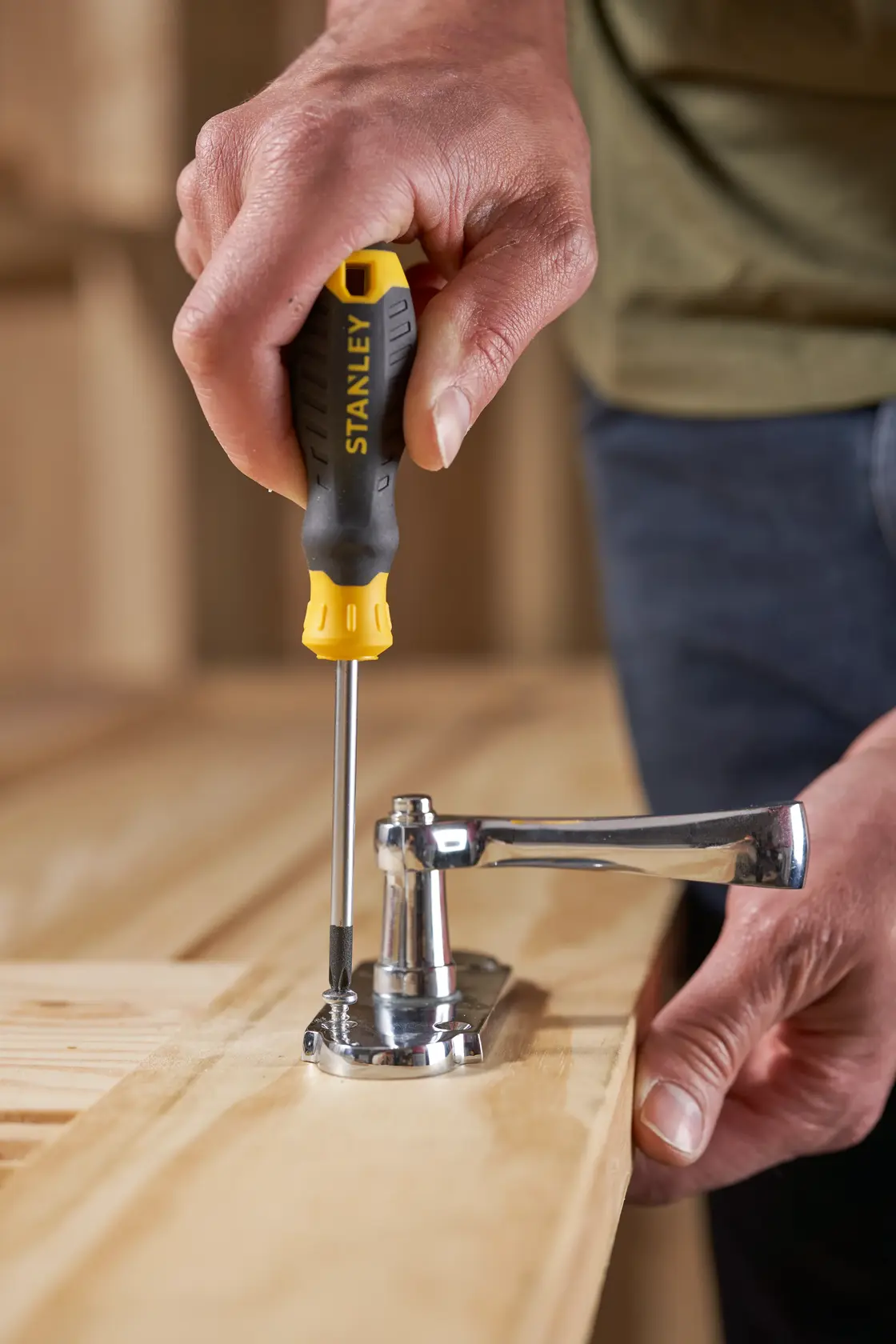 Stanley STHT16155-0 cacciavite usato per fissare una maniglia alla superficie di legno.