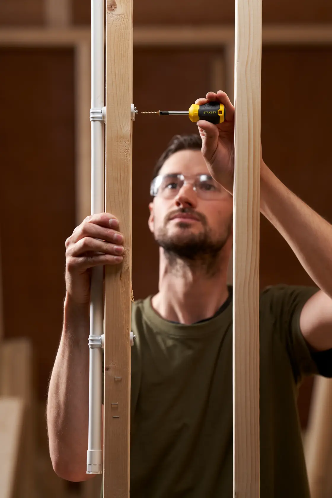Foto del cacciavite STANLEY STHT16196-0 utilizzato da una persona per installare una vite in una cornice di legno.