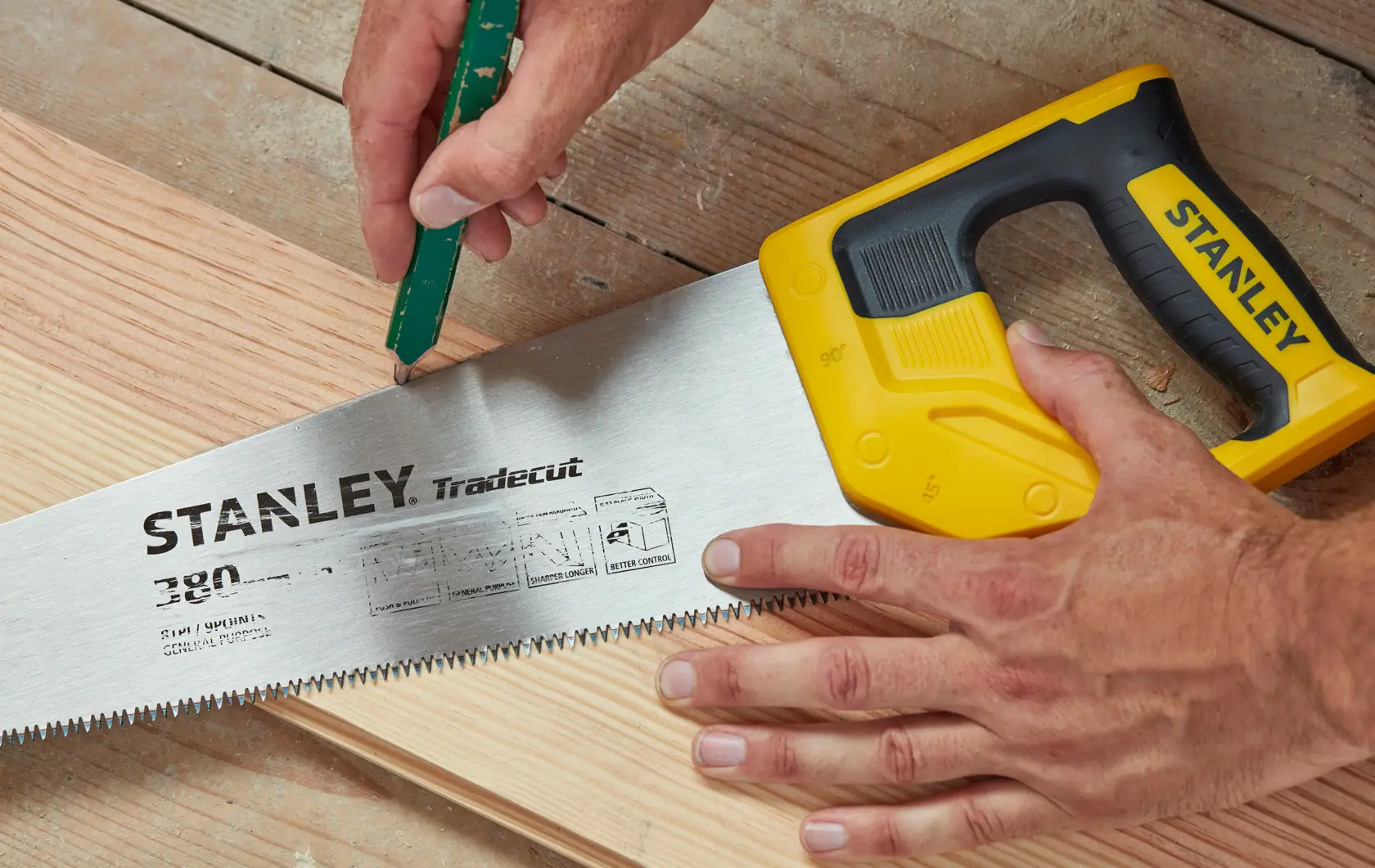 STANLEY STHT20348-1 sega manuale con manico giallo su legno, dettaglio ravvicinato dei denti e marchio.