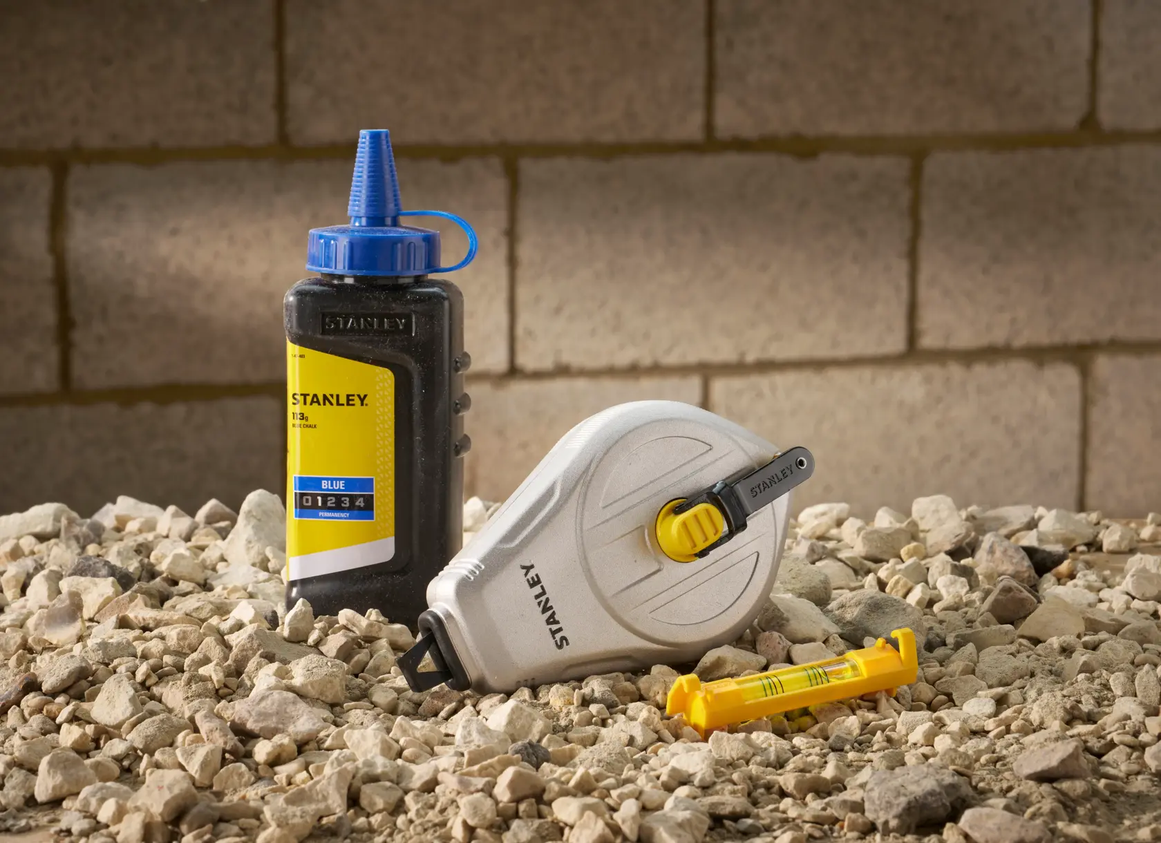 STANLEY STHT47111 set linea di gesso con flacone di gesso e livella su terreno roccioso.