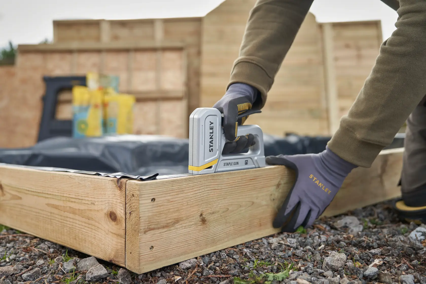 STANLEY STHT70150-0 graffatrice in uso per fissare plastica su una cornice di legno all’aperto.