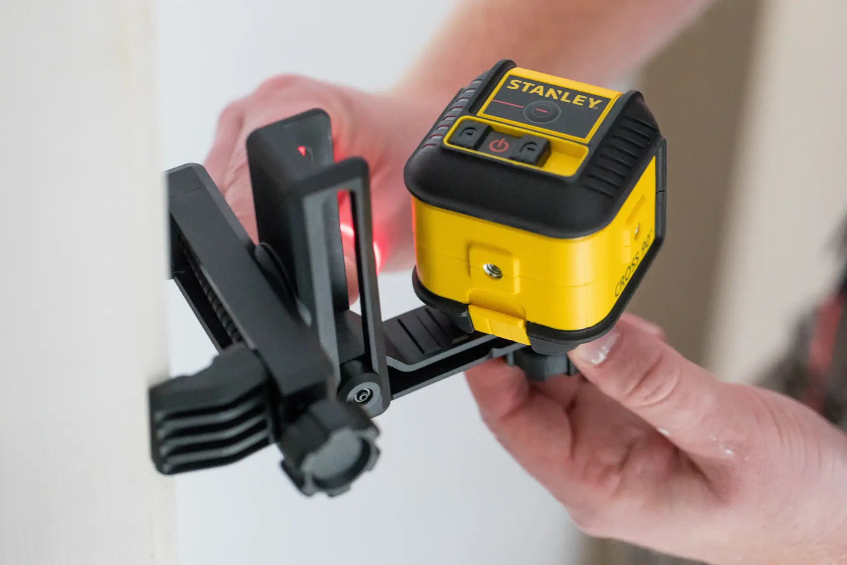 STANLEY STHT77502-1 livella laser gialla e nera montata su staffa regolabile, in uso.