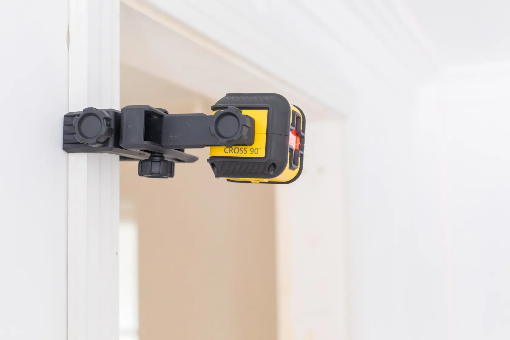 Livella laser STANLEY STHT77502-1 con morsetto su telaio porta, vista laterale, giallo e nero.