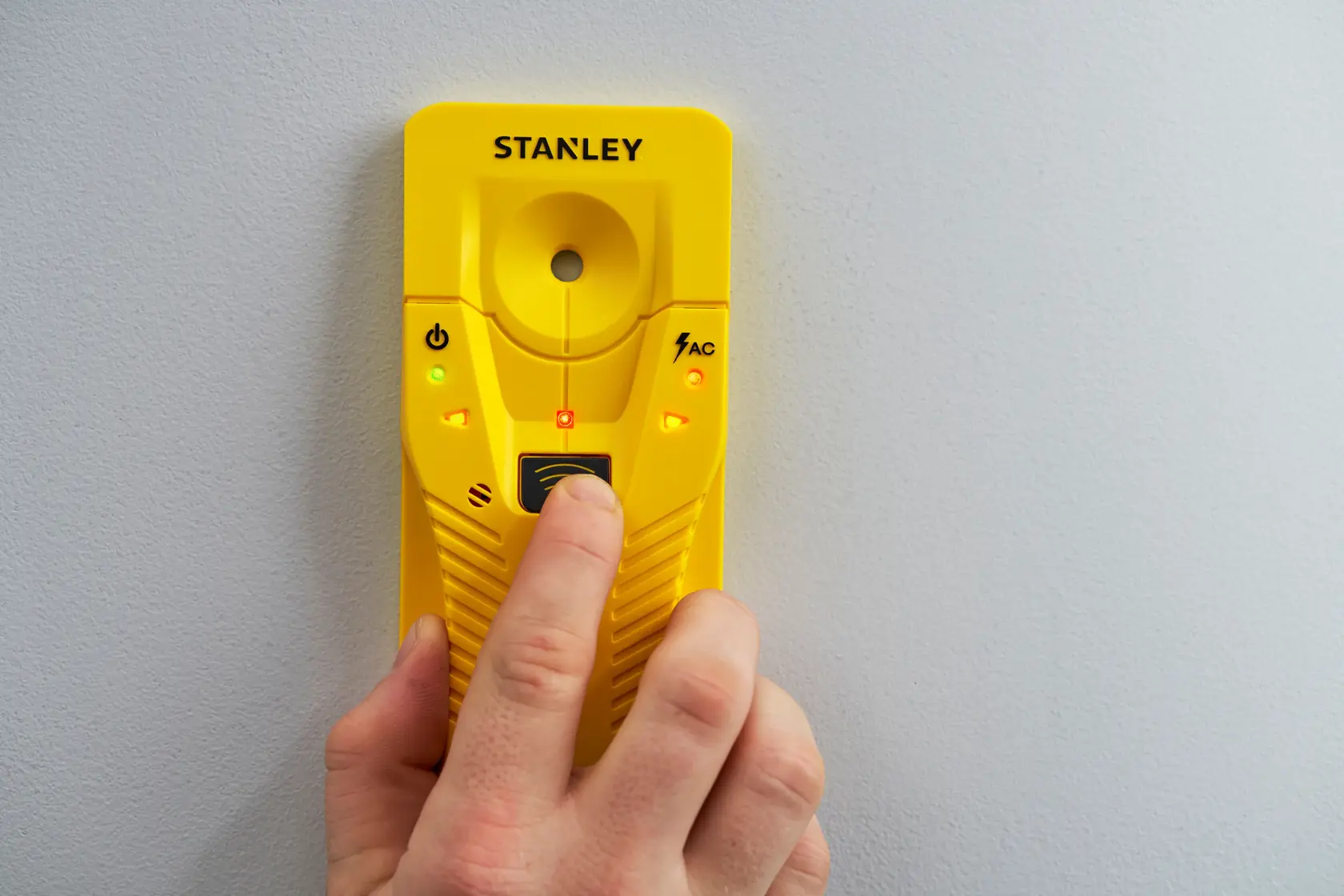 STANLEY STHT77587-0 cercatore di montanti giallo contro la parete, vista frontale, luci accese.
