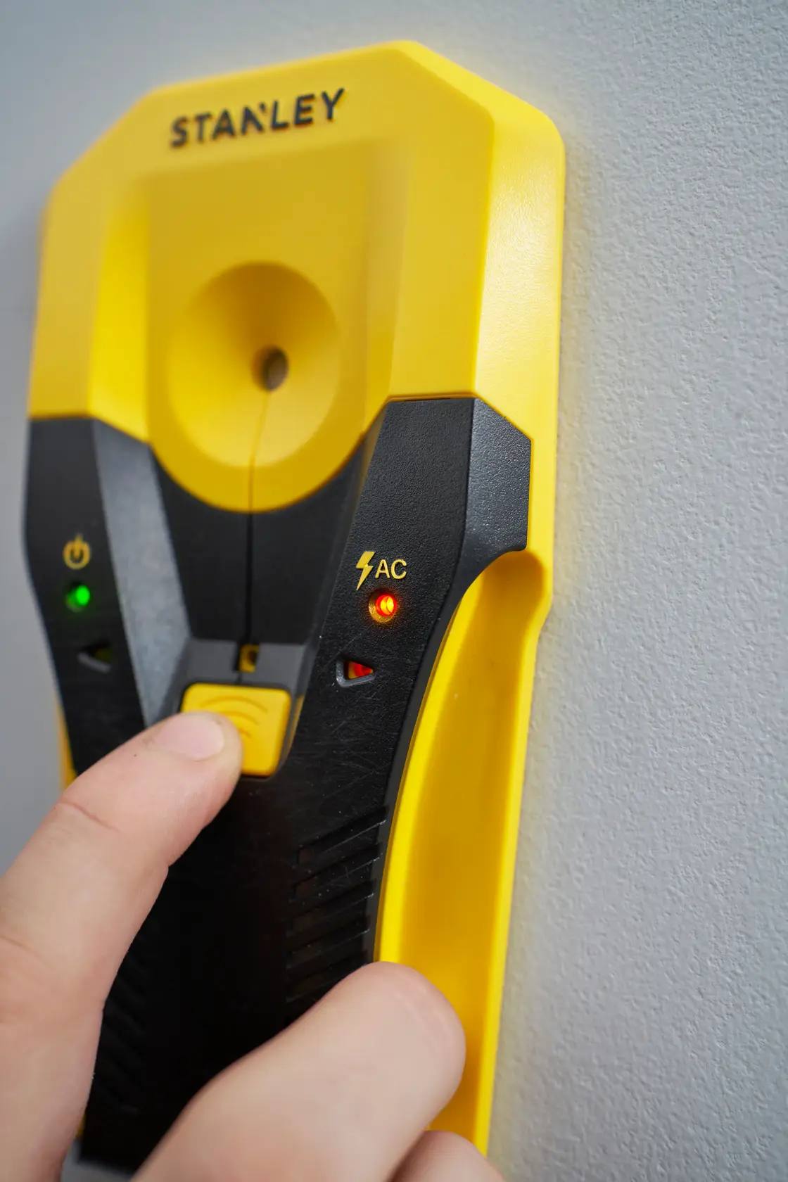Foto del rilevatore digitale STANLEY STHT77588-0 giallo e nero con spie luminose, posizionato contro una parete.