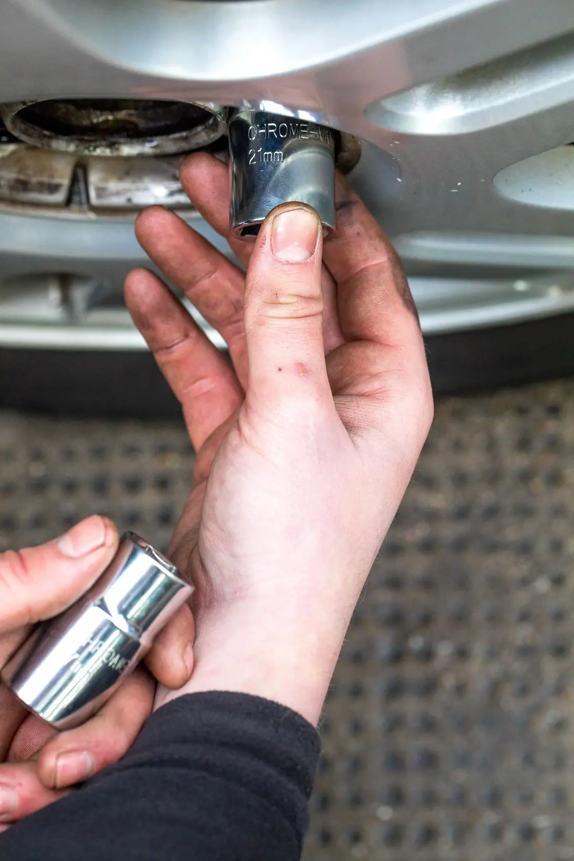 STANLEY STHT80890-0 bussola usata per rimuovere un dado ruota auto, vista ravvicinata della mano.