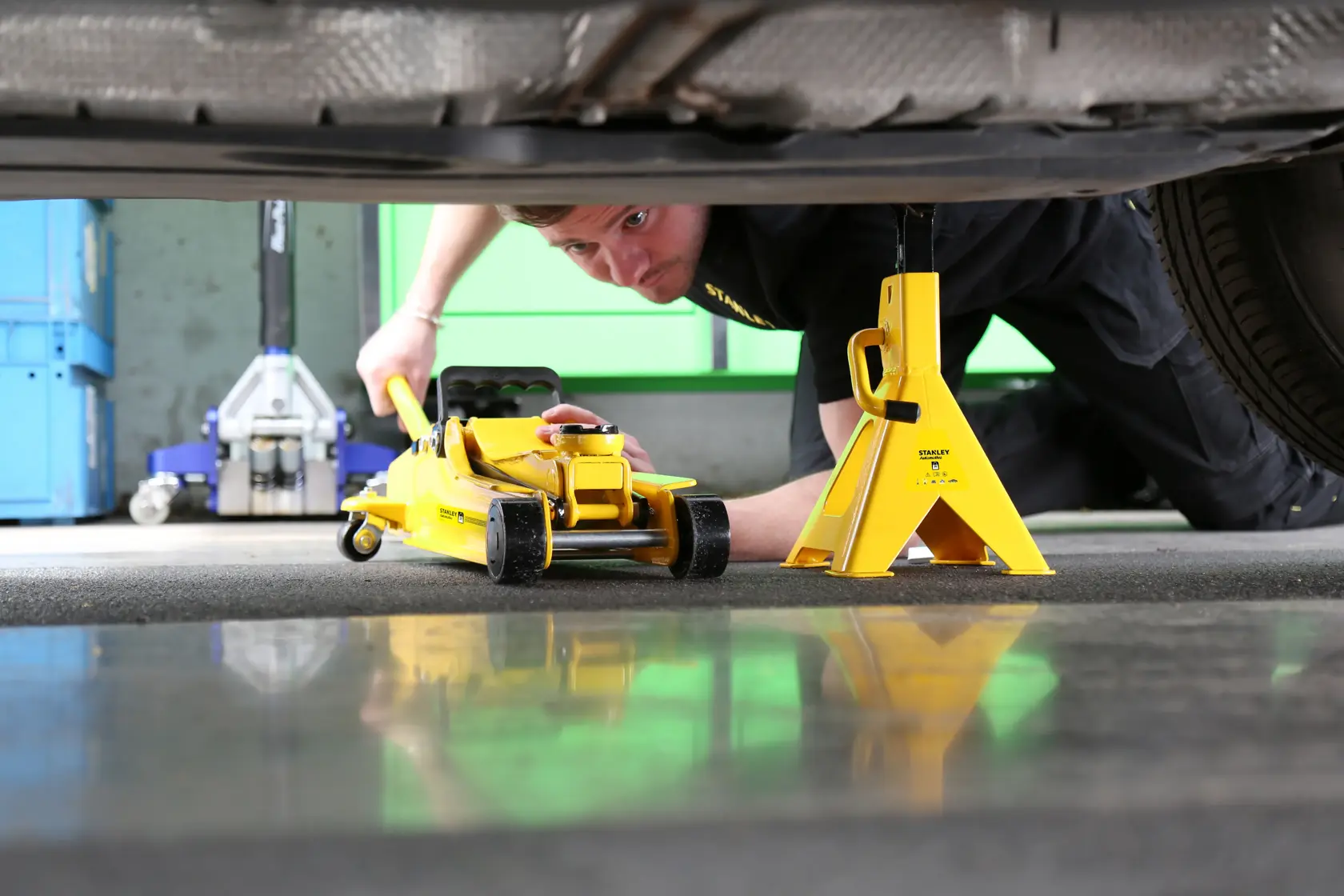 STANLEY STMT81255-1 cavalletto giallo e cric da pavimento sotto auto, vista laterale, utensile automobilistico.