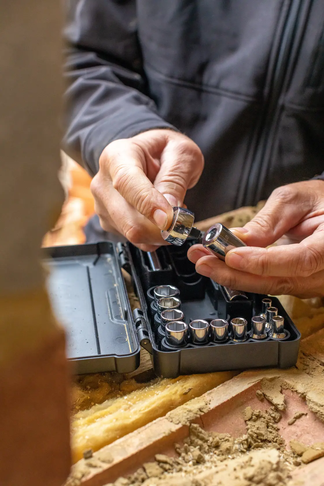 STANLEY STMT82672-0 set di bussole in custodia nera, mani che scelgono una bussola, primo piano in cantiere.