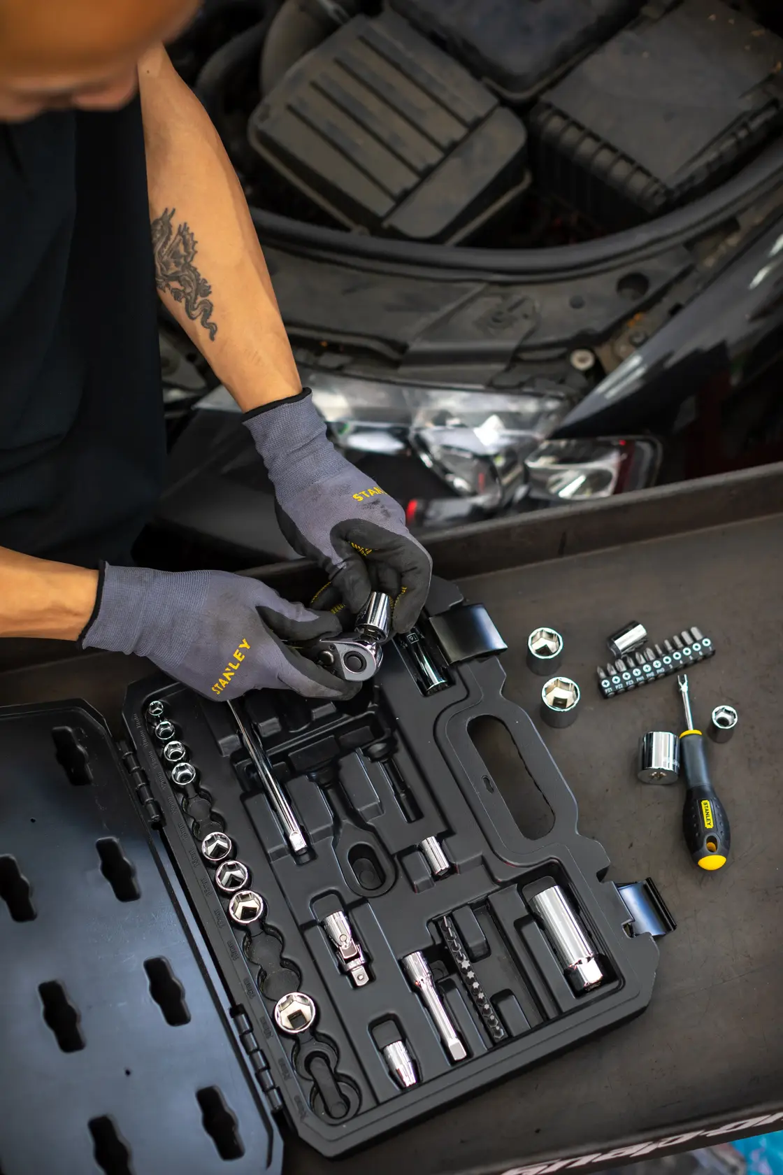 STANLEY STMT82828-1 kit di bussole in valigetta nera, meccanico usa attrezzi vicino al motore, foto dall'alto.