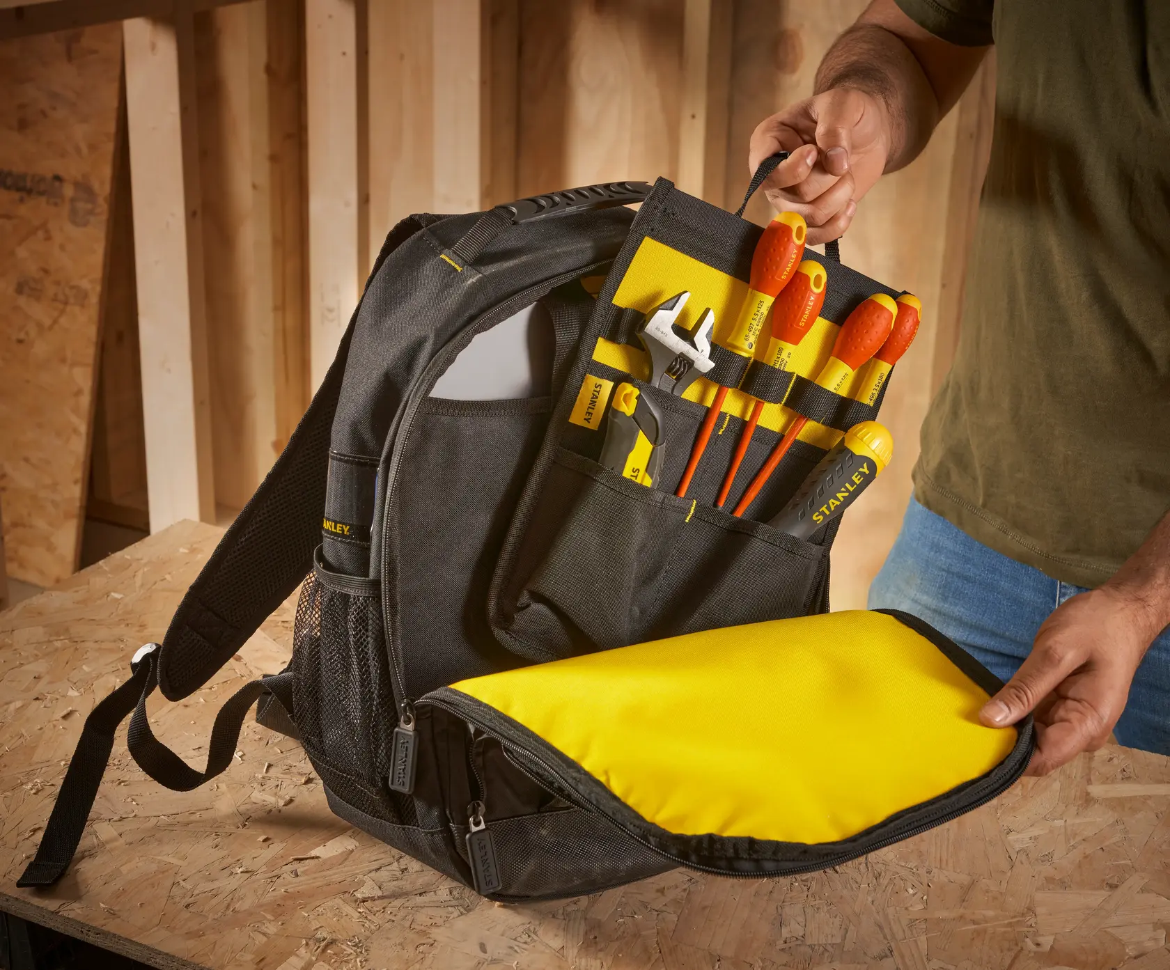 STANLEY STST1-72335 zaino porta attrezzi con interno giallo, pieno di utensili manuali, aperto su superficie.