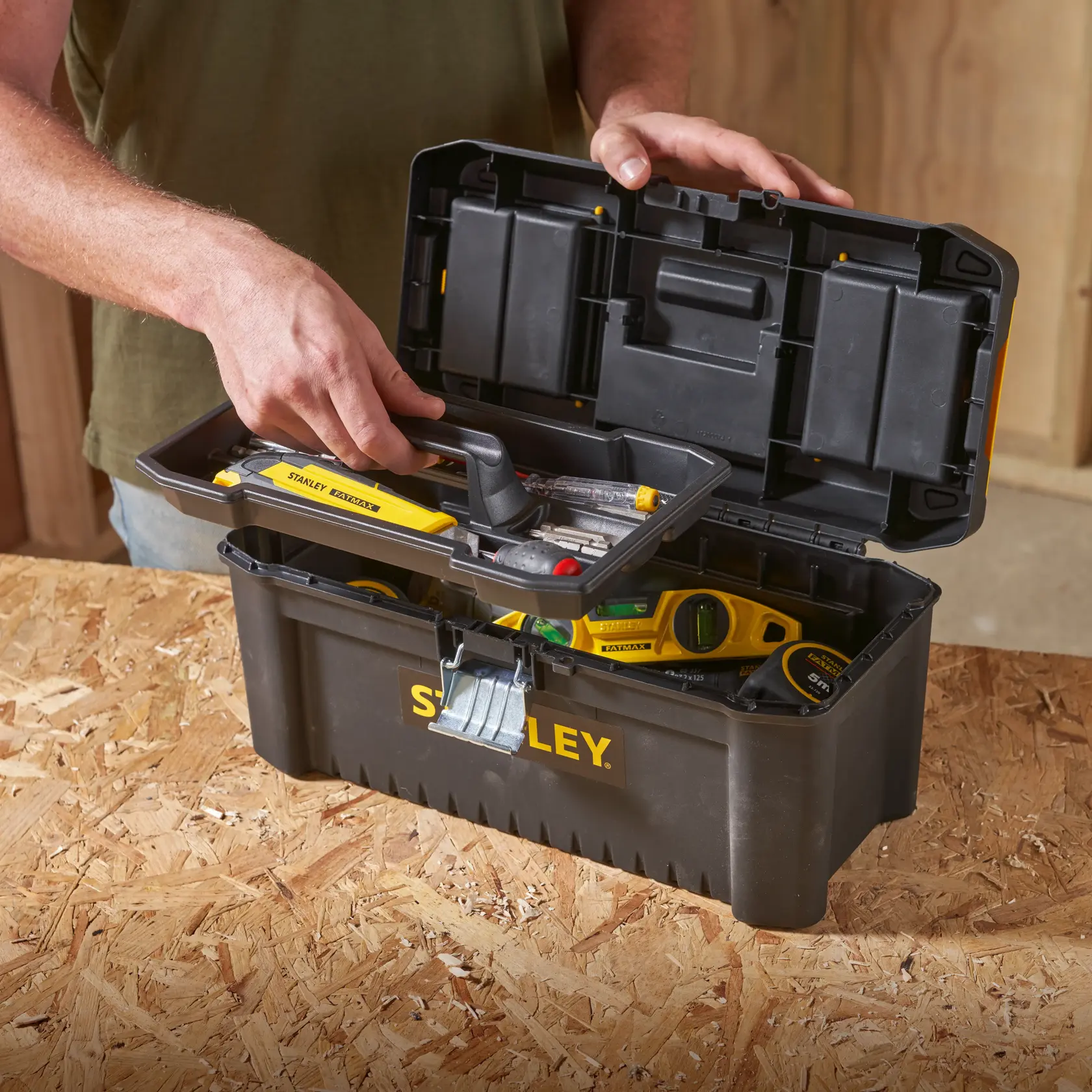 STANLEY STST1-75518-KR cassetta degli attrezzi nera con vassoio, piena di utensili, su superficie di legno.