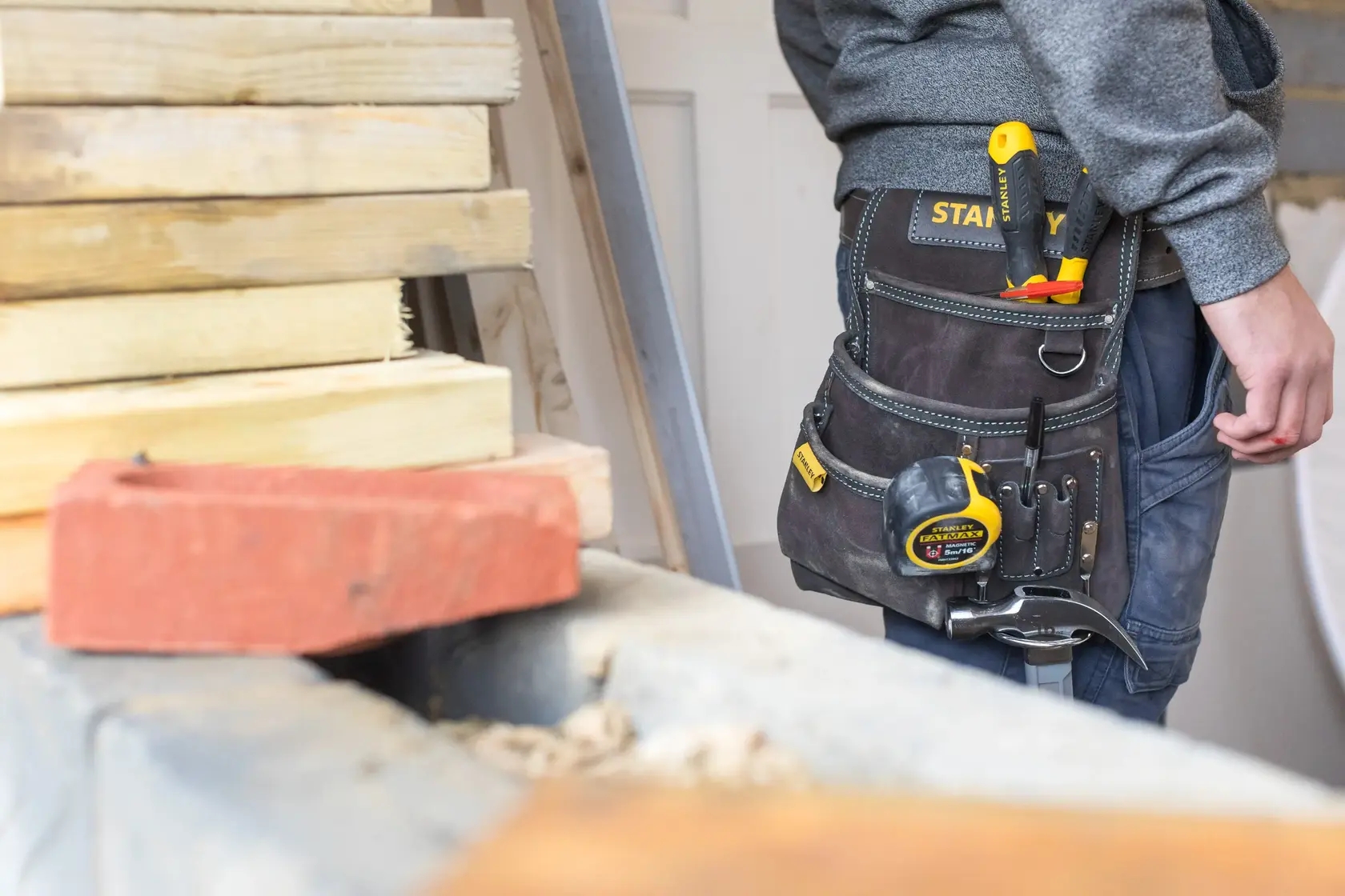 Foto della cintura porta attrezzi STANLEY STST1-80114 con metro giallo e utensili indossata in cantiere.
