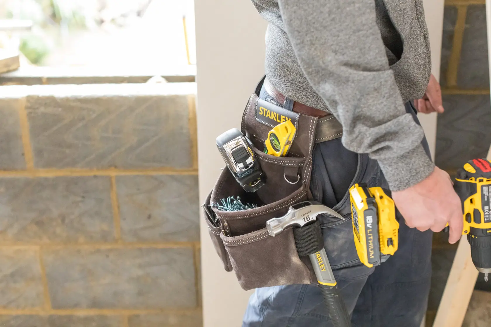 Fotografia di cintura porta attrezzi STANLEY STST1-80116 con utensili, indossata da persona in cantiere.