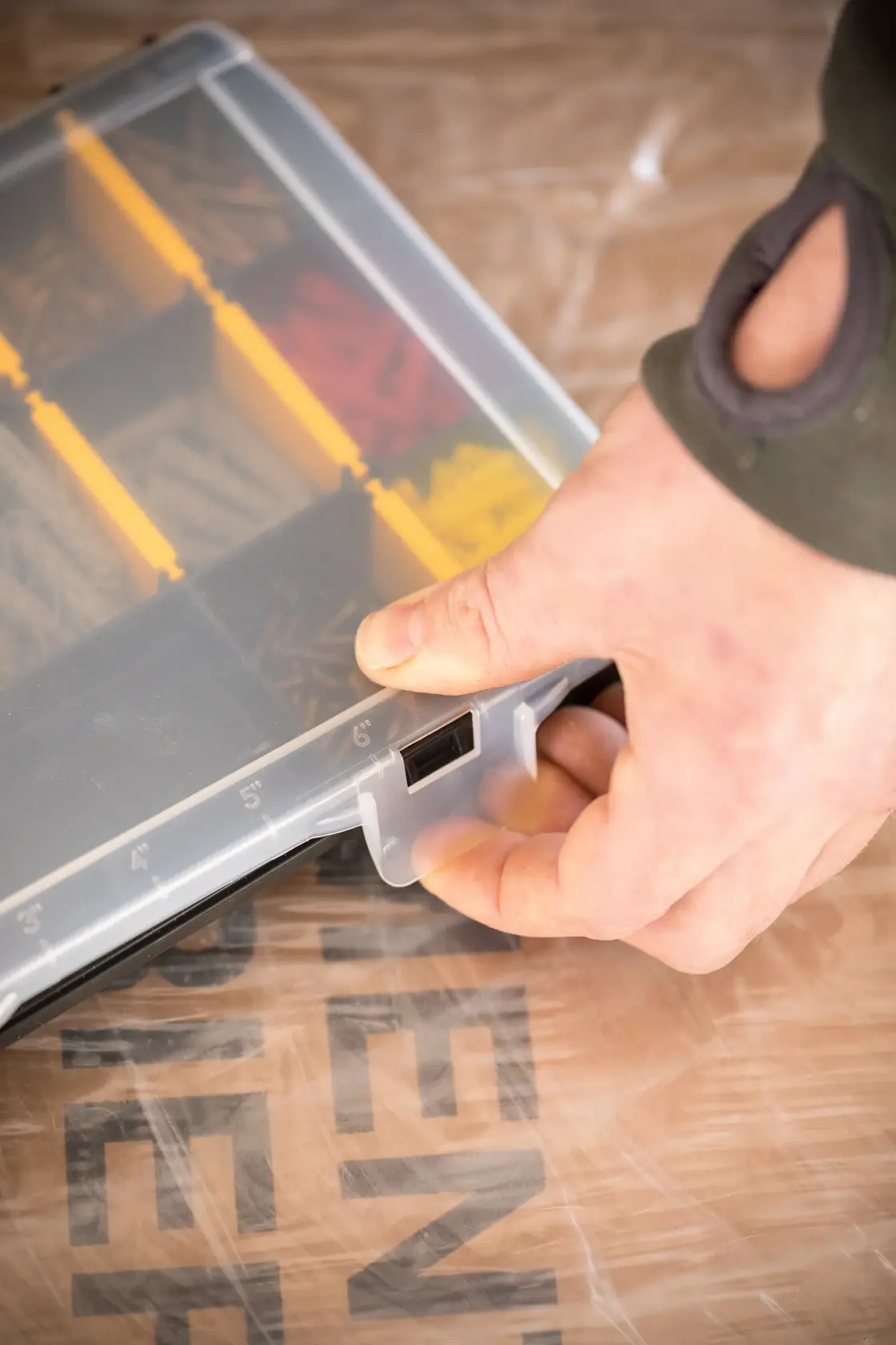 STANLEY STST81680-1 organizer per minuteria con coperchio trasparente, divisori gialli, mano che apre la chiusura, vista angolare.