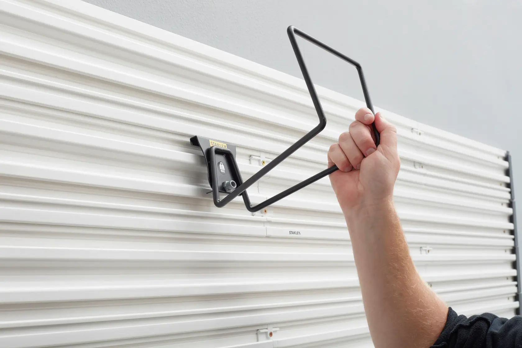 Installazione del gancio portaoggetti STANLEY STST82604-1 su pannello bianco, vista laterale.