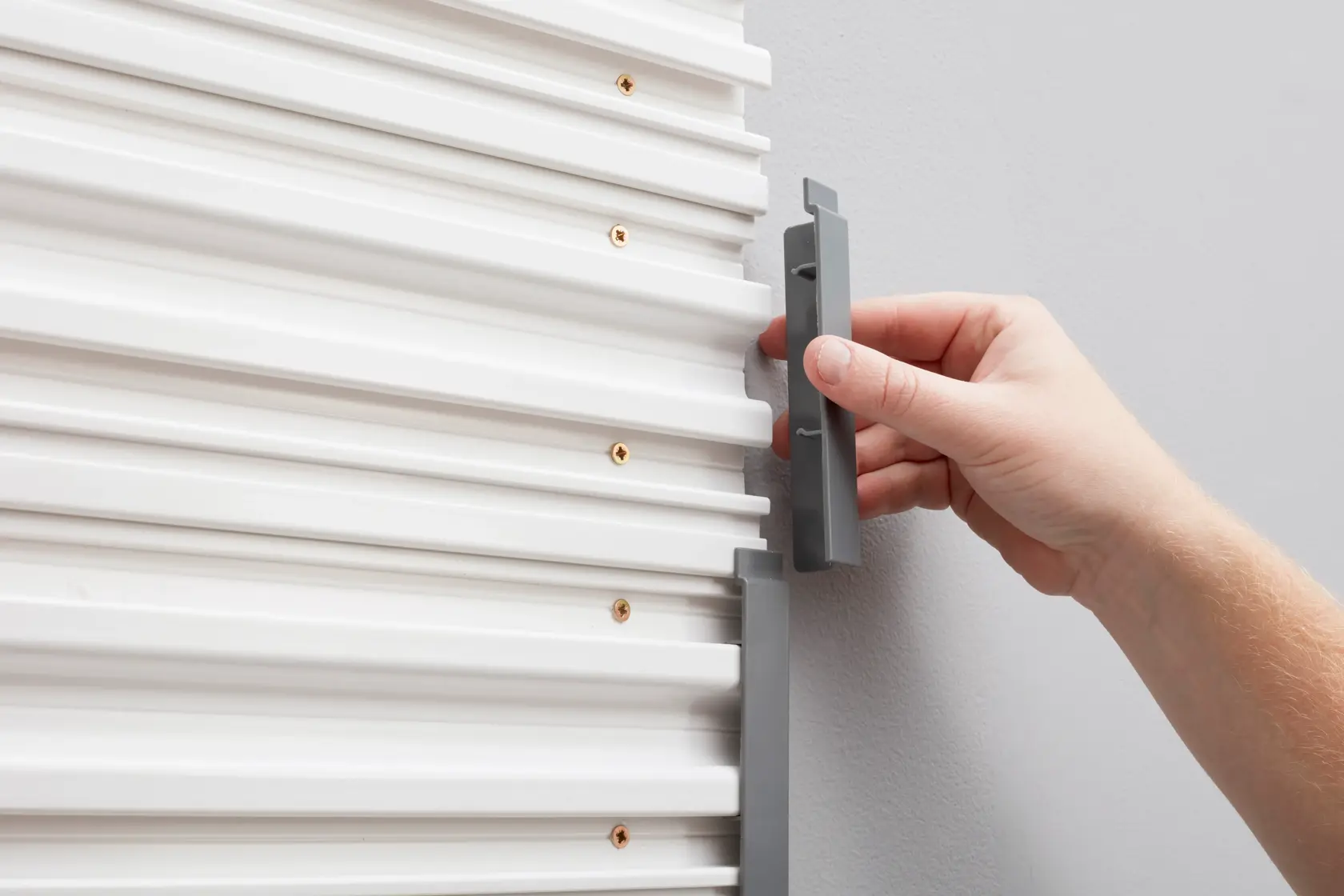 Tappo terminale grigio STANLEY STST82611-1 installato su pannello murale bianco, fotografia ravvicinata.