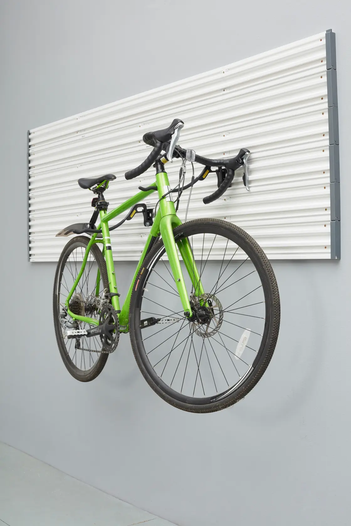 Pannello a muro STANLEY STST82615-1 con bicicletta verde appesa, foto angolata laterale.