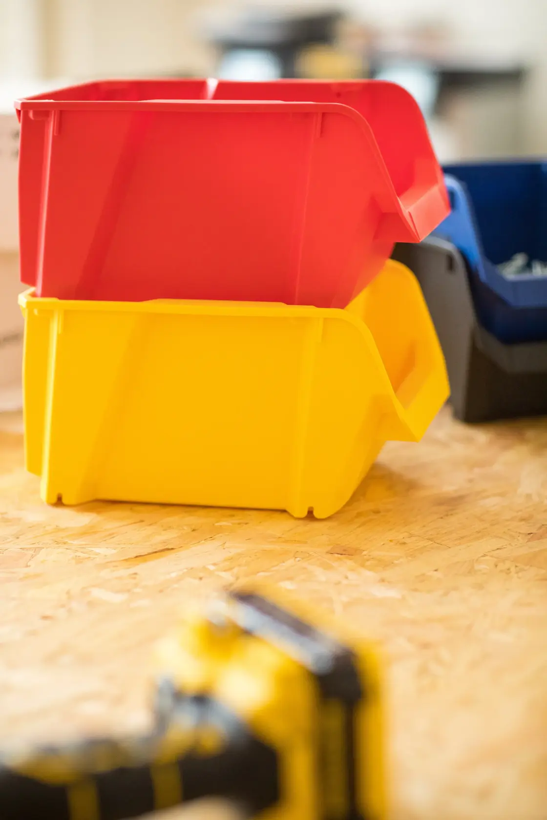 STANLEY STST82739-1 contenitori impilabili rosso e giallo su superficie in legno, fotografia laterale.