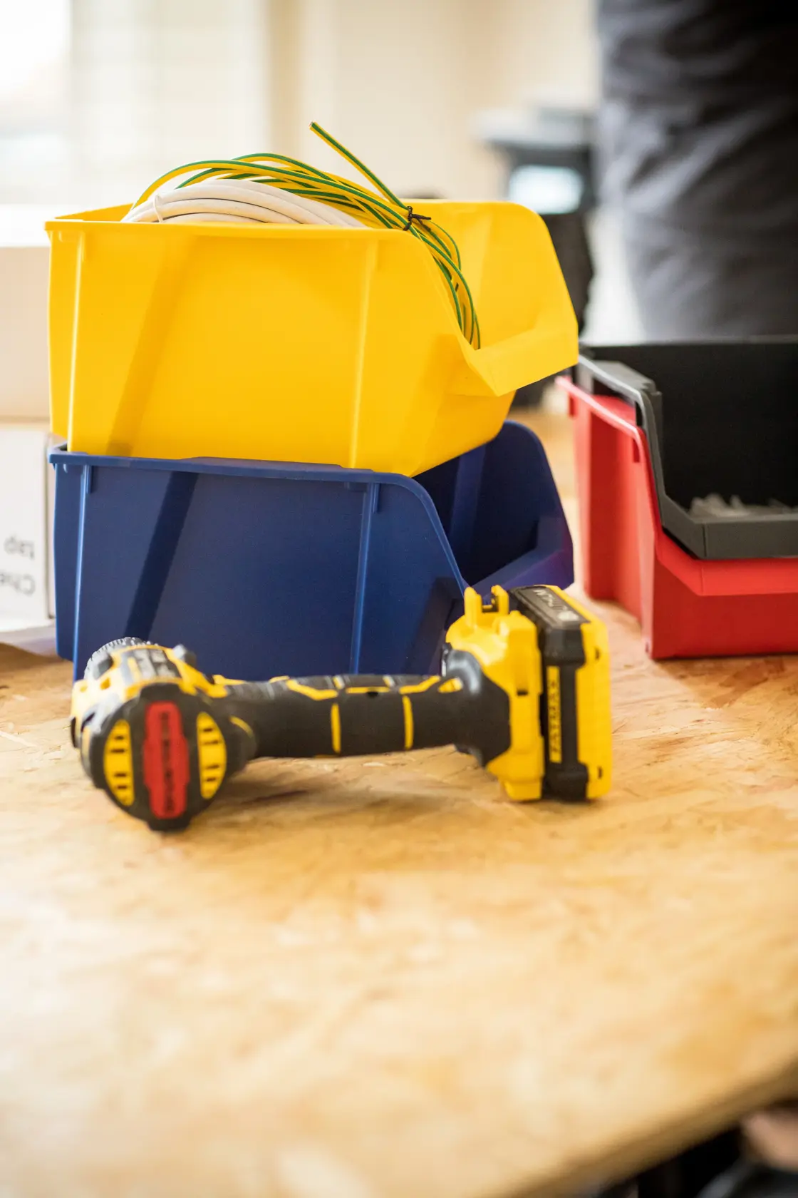 Contenitori STANLEY STST82740-1 giallo, blu, rosso con attrezzi su superficie di legno, angolo fotografico.