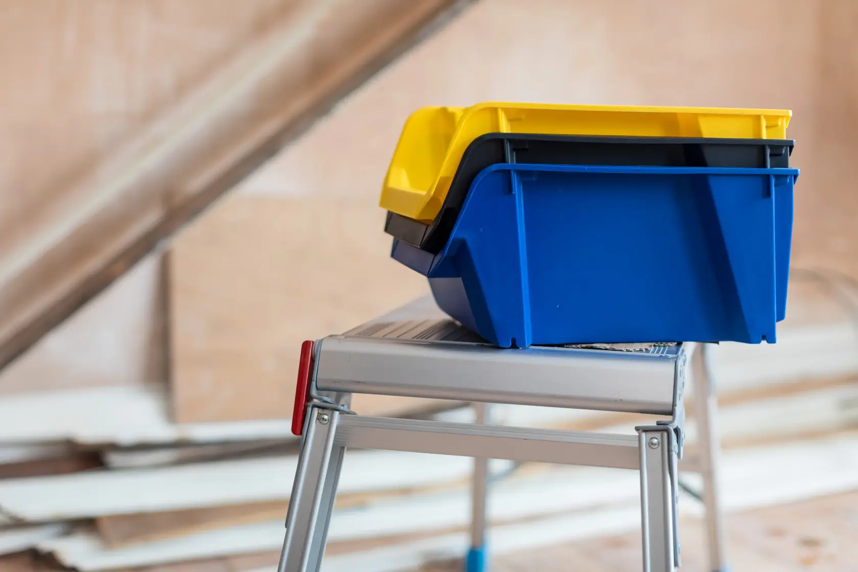 STANLEY STST82743-1 contenitori impilabili giallo e blu su scala di metallo, vista laterale.